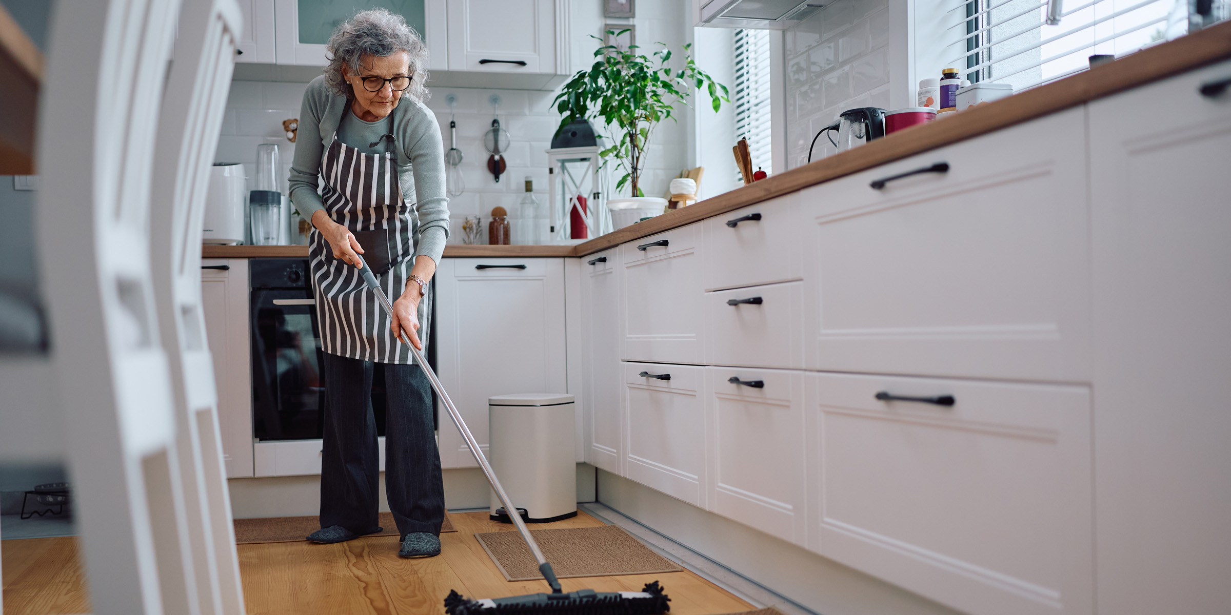Una anciana limpiando el suelo | Fuente: Shutterstock