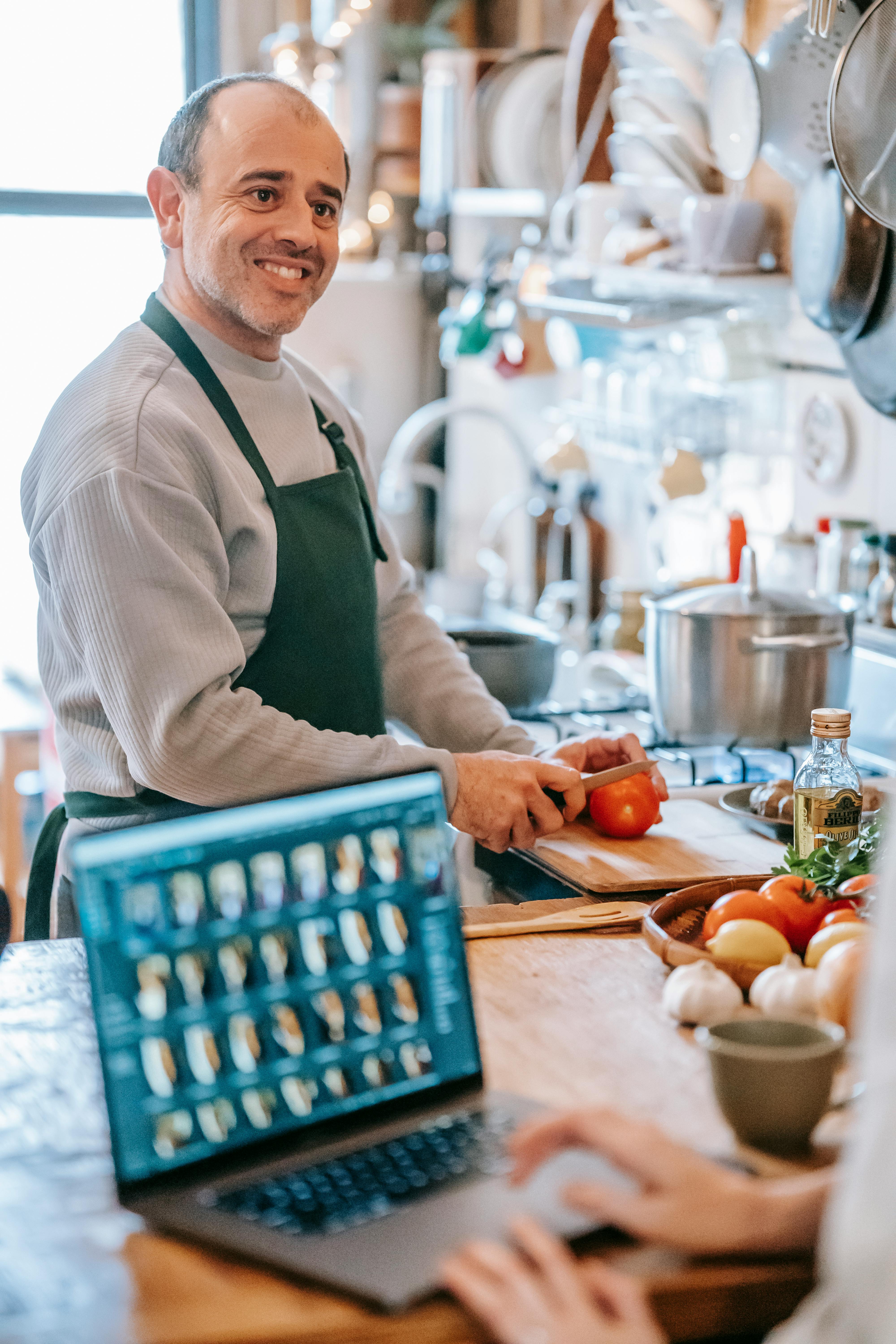 Un hombre sonriente preparando una comida | Fuente: Pexels