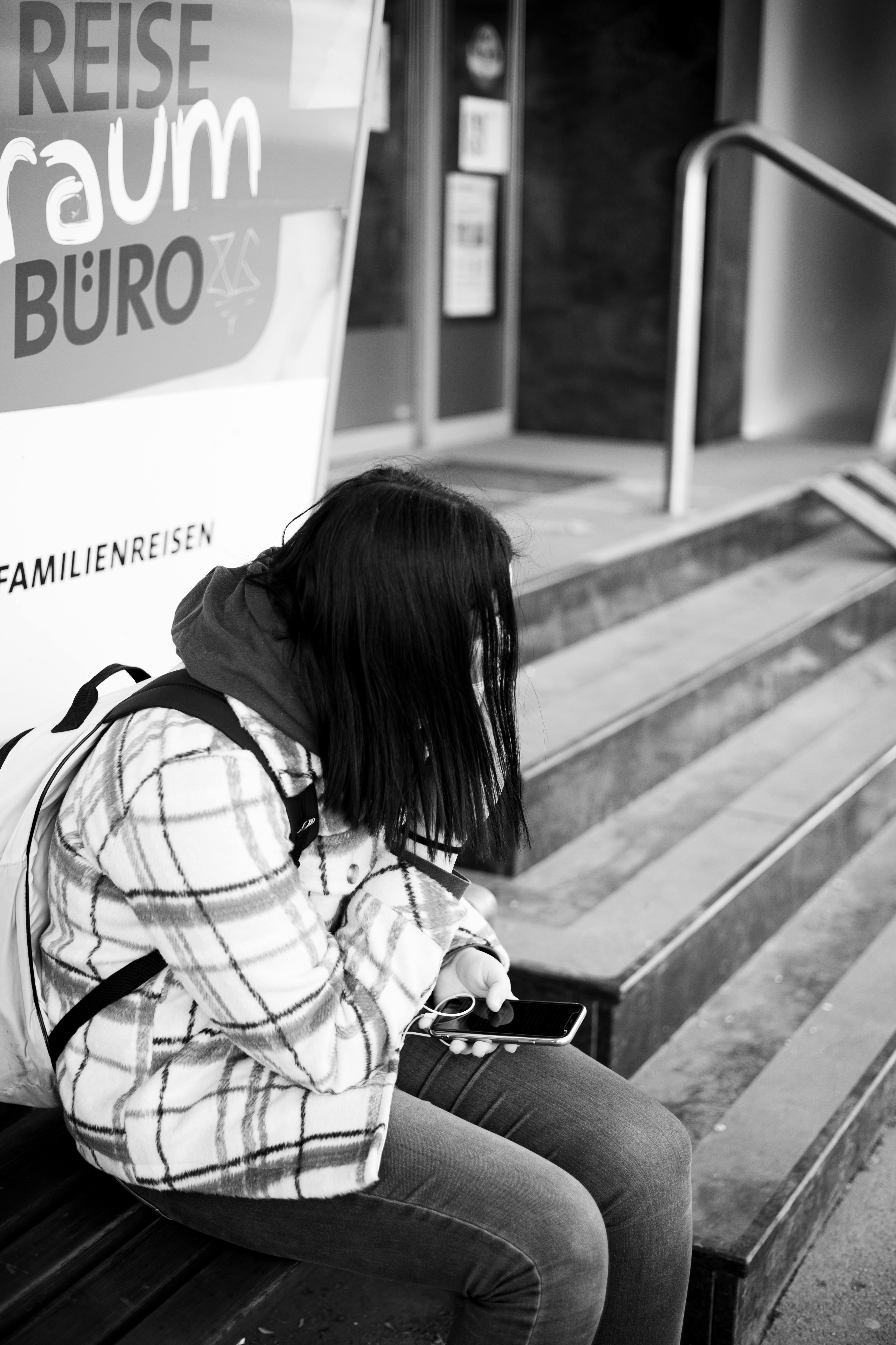Una chica sentada en un banco sujetando su teléfono | Fuente: Pexels