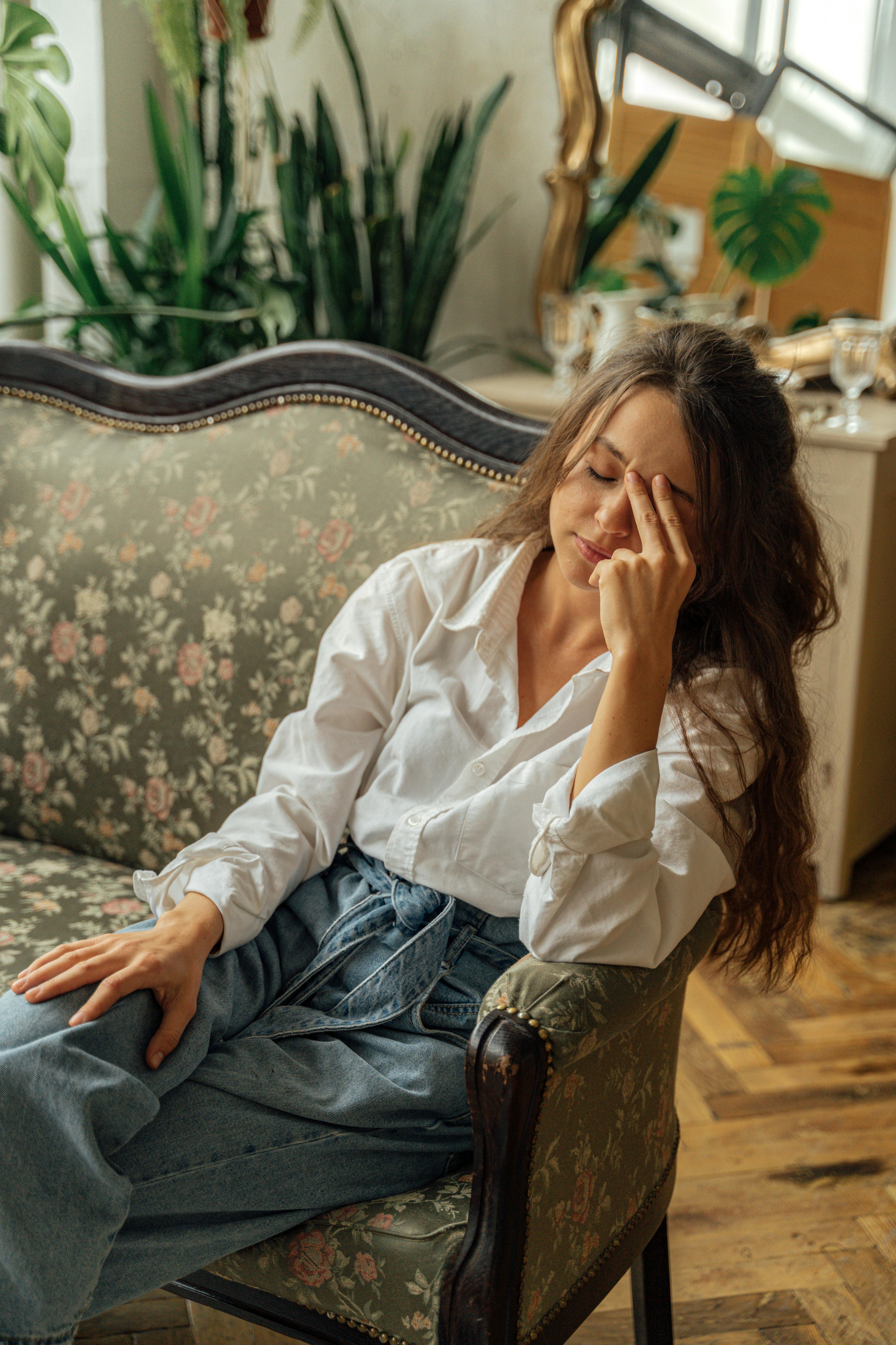Mujer estresada sentada en un sofá | Fuente:  Pexels