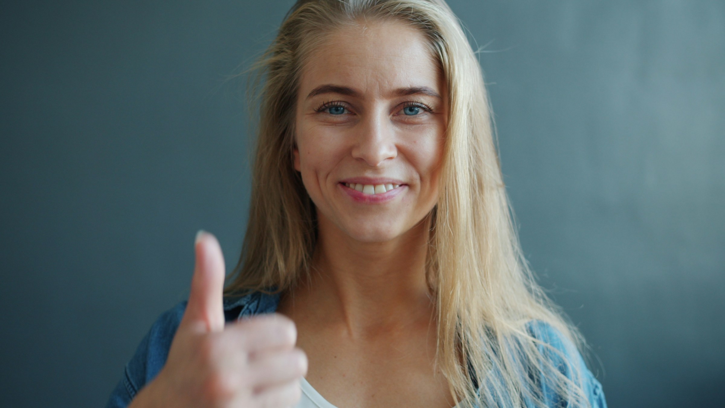 Una mujer sonriente mostrando un signo de pulgar hacia arriba | Fuente: Unsplash