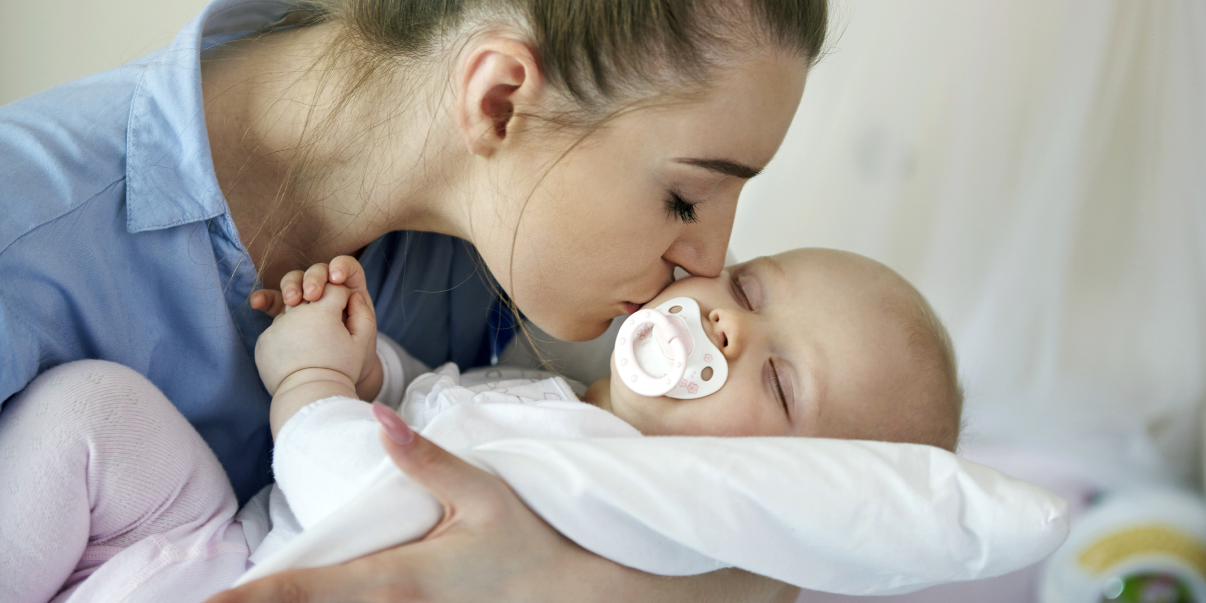 Una mujer besando a su bebé | Fuente: Freepik