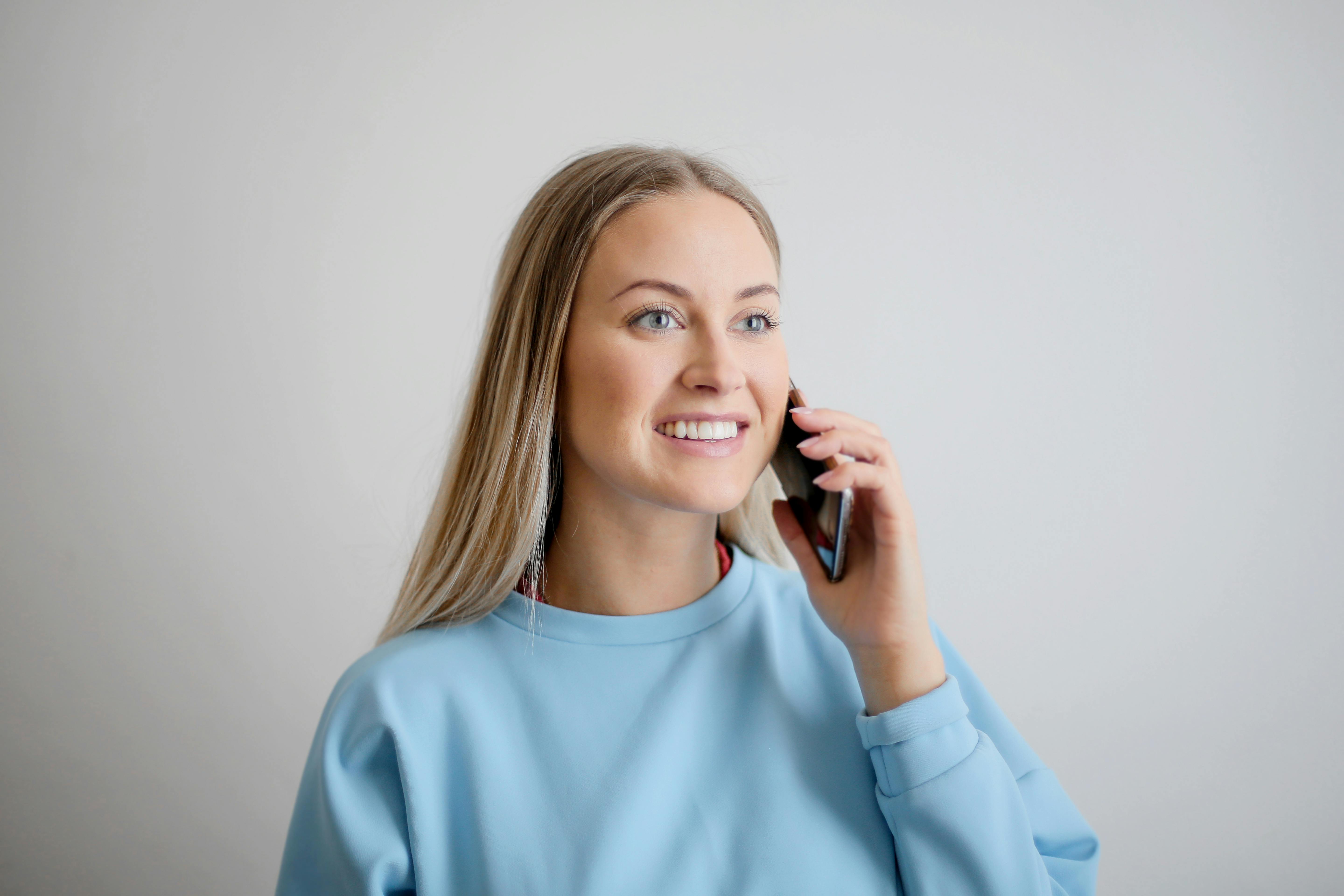 Una mujer sonriente hablando por teléfono | Fuente: Pexels
