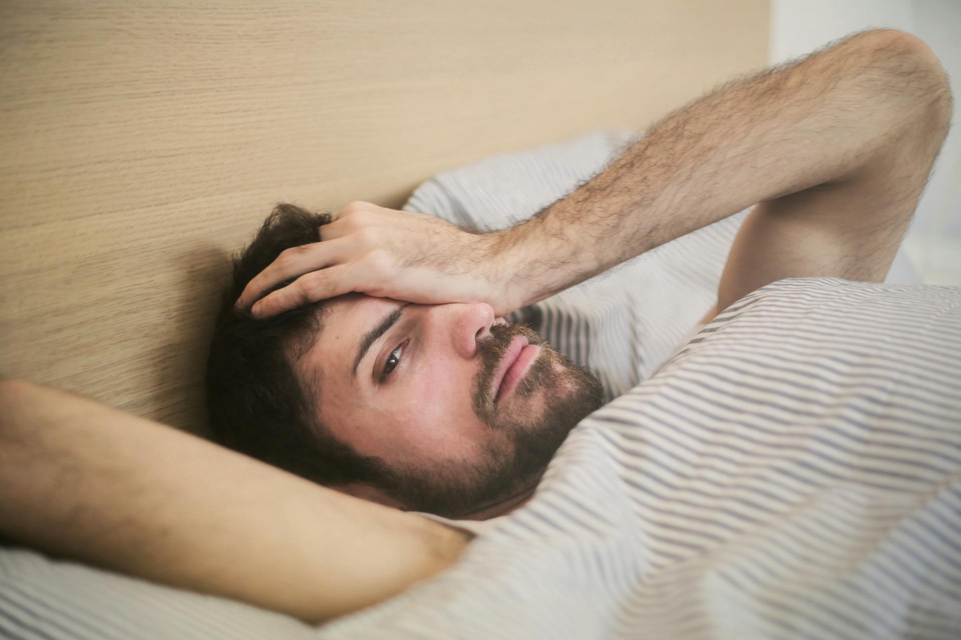 Un hombre tumbado en la cama | Fuente: Pexels