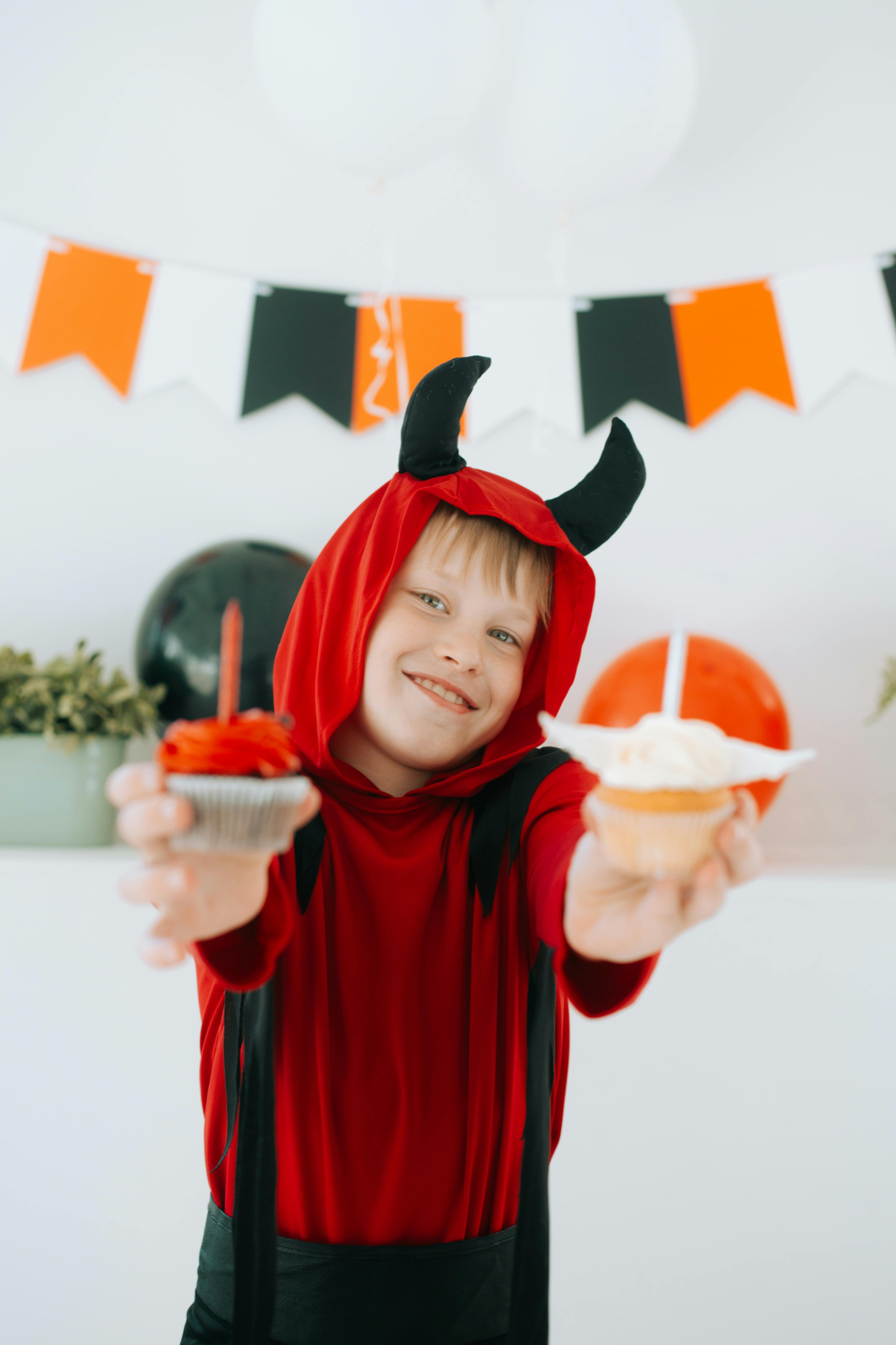Un niño disfrazado para Halloween y con golosinas en la mano | Fuente: Pexels