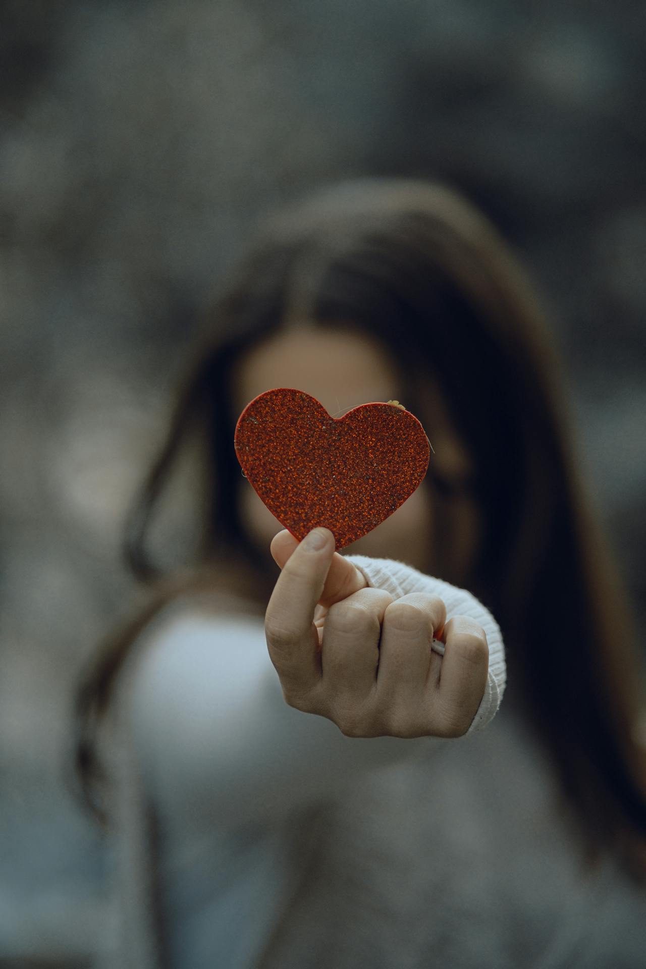 Una mujer con un corazón de papel brillante | Fuente: Pexels