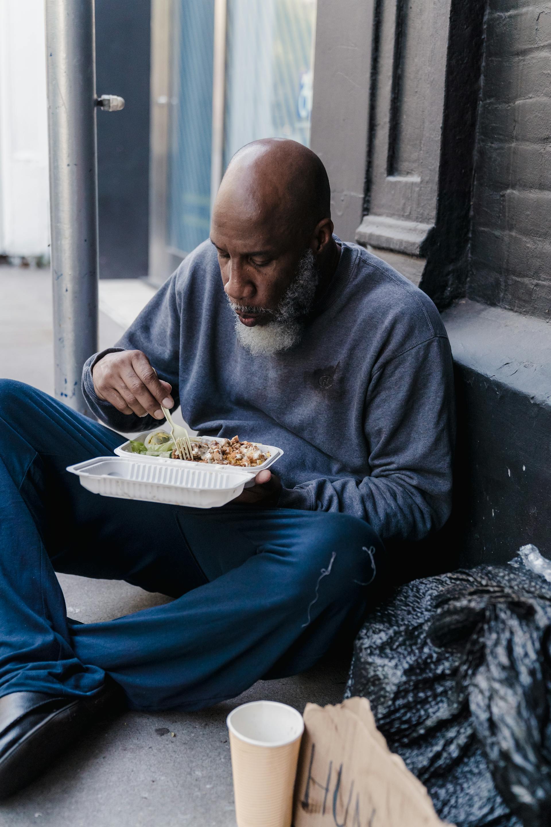 Un vagabundo comiendo su comida | Fuente: Pexels