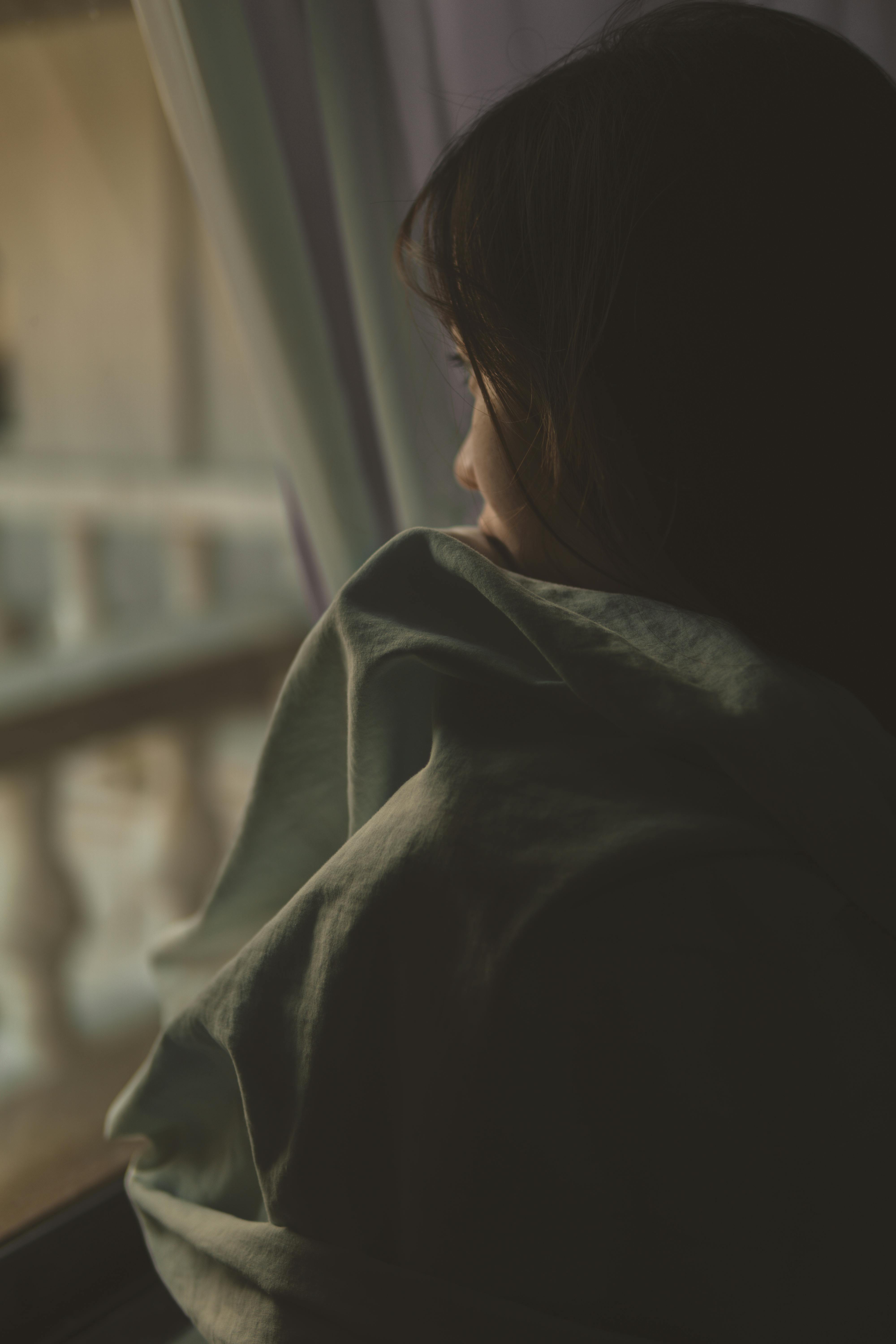 Una mujer triste mirando por la ventana | Fuente: Pexels