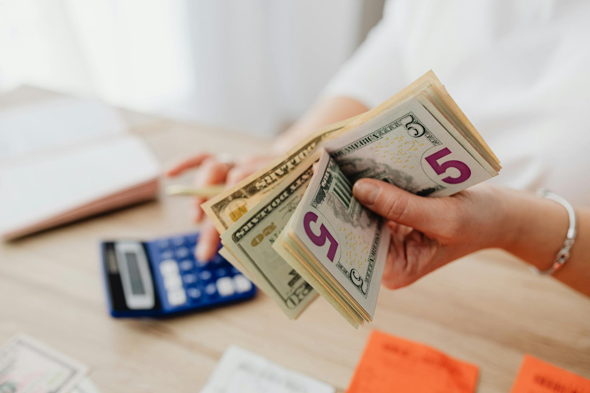 Una mujer con dinero en la mano | Fuente: Pexels