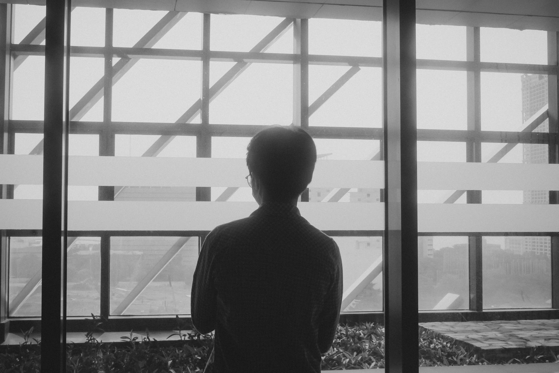 Un hombre de pie cerca de una ventana | Fuente: Pexels
