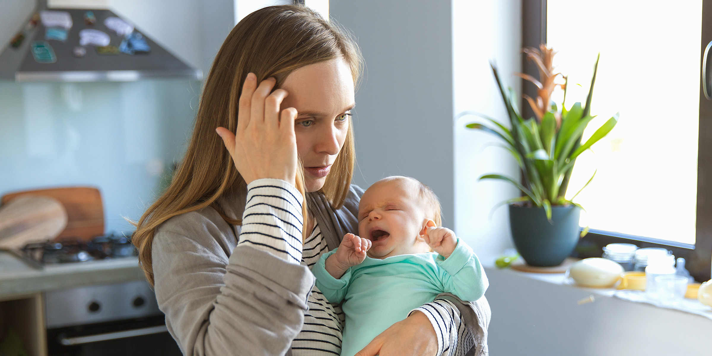 Una mujer con un bebé llorando en brazos | Fuente: Shutterstock