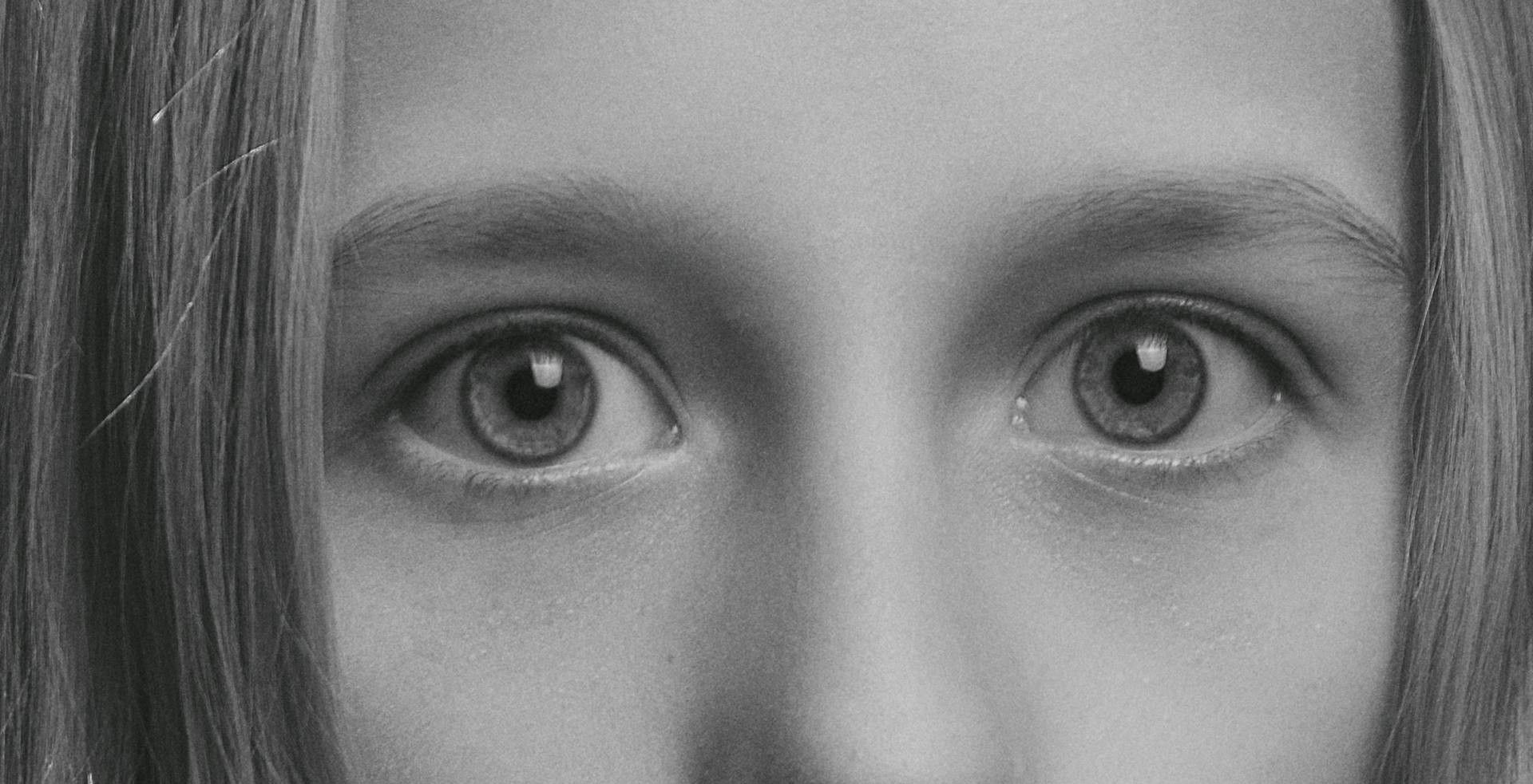 Toma en escala de grises de los ojos de una niña asustada | Fuente: Pexels