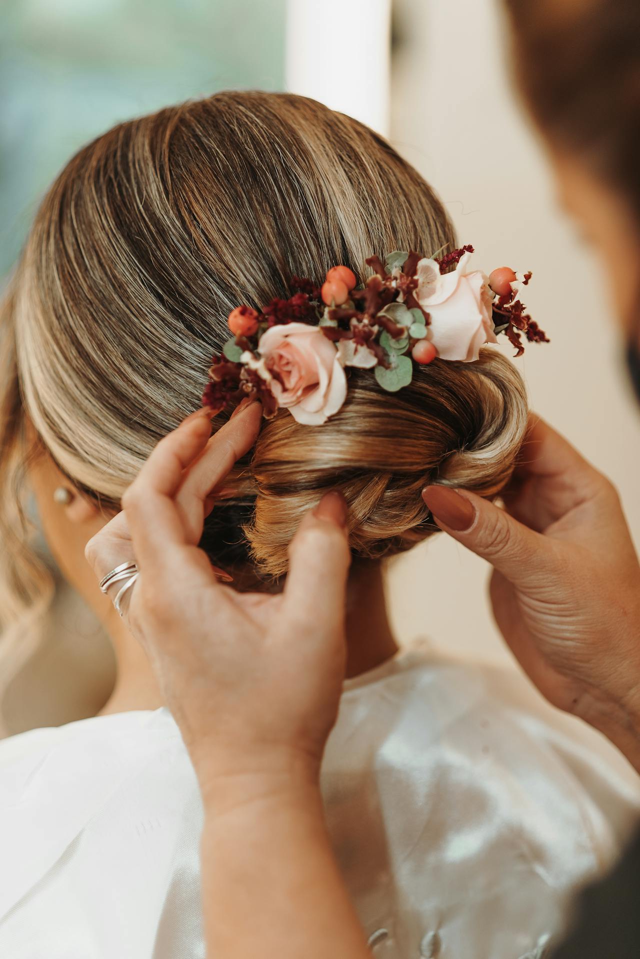 Una mujer arreglando el cabello de la novia | Fuente: Pexels