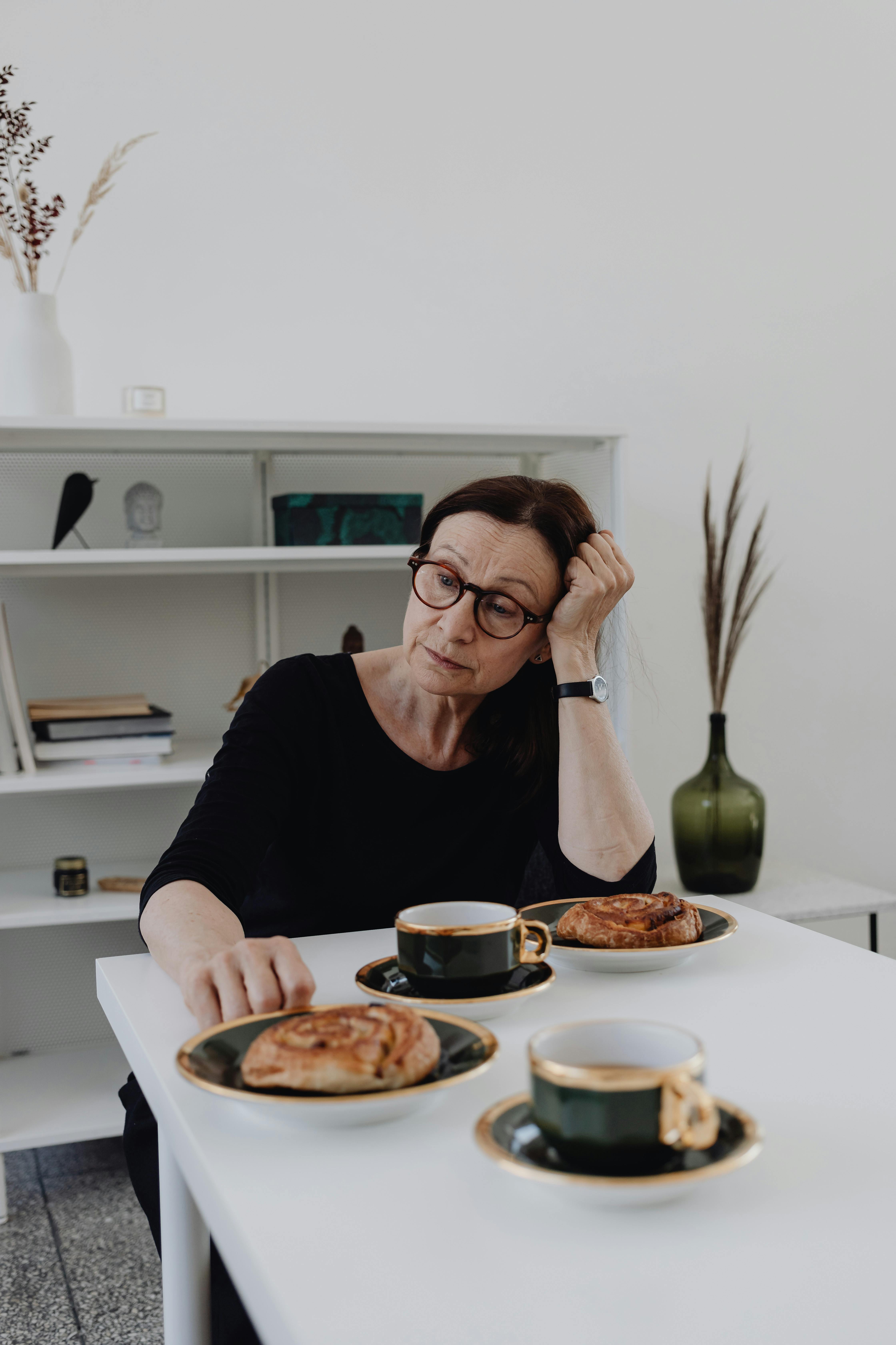 Una mujer triste sentada a la mesa | Fuente: Pexels