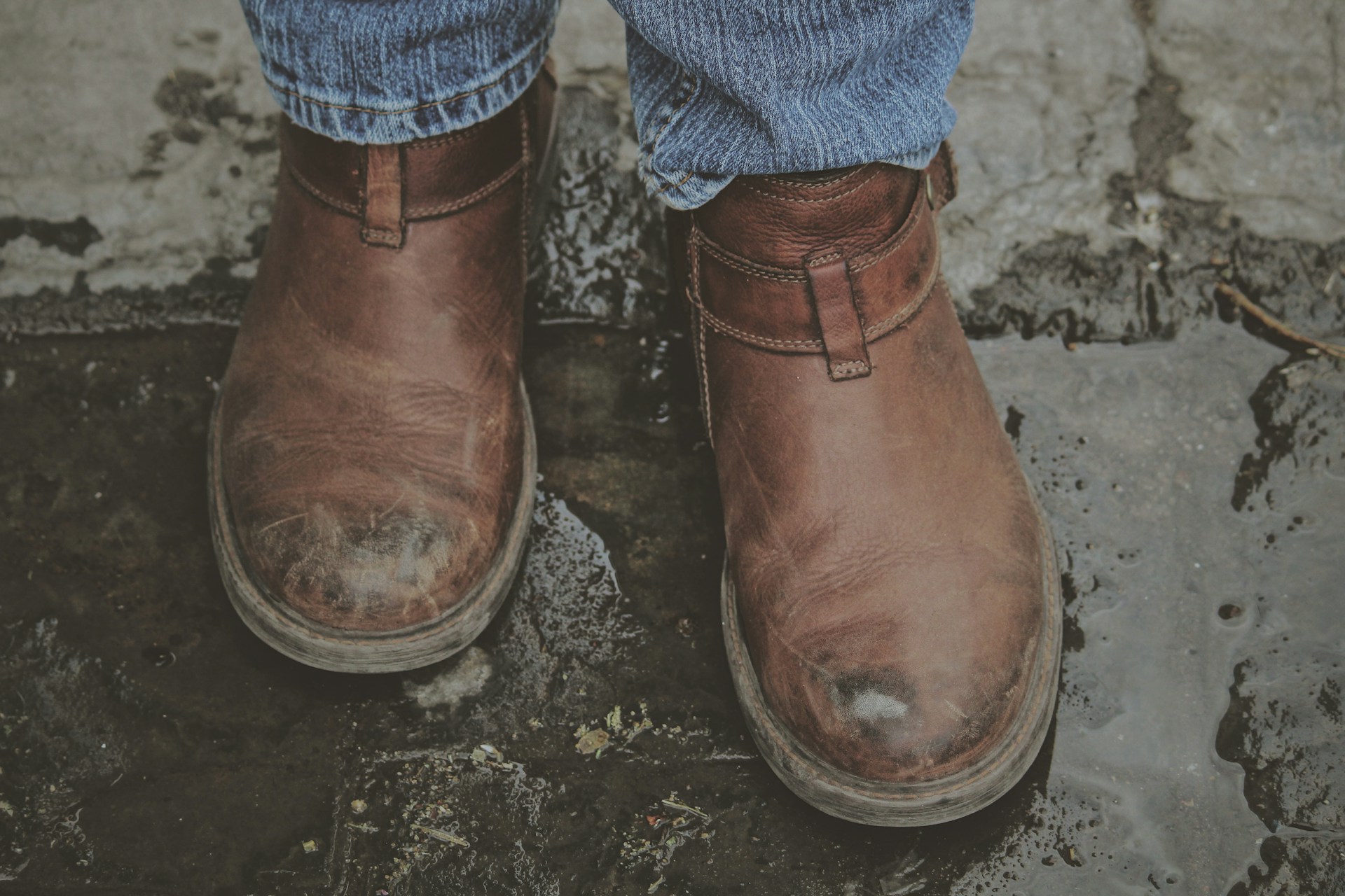 Alguien con botas caminando por un charco | Fuente: Unsplash
