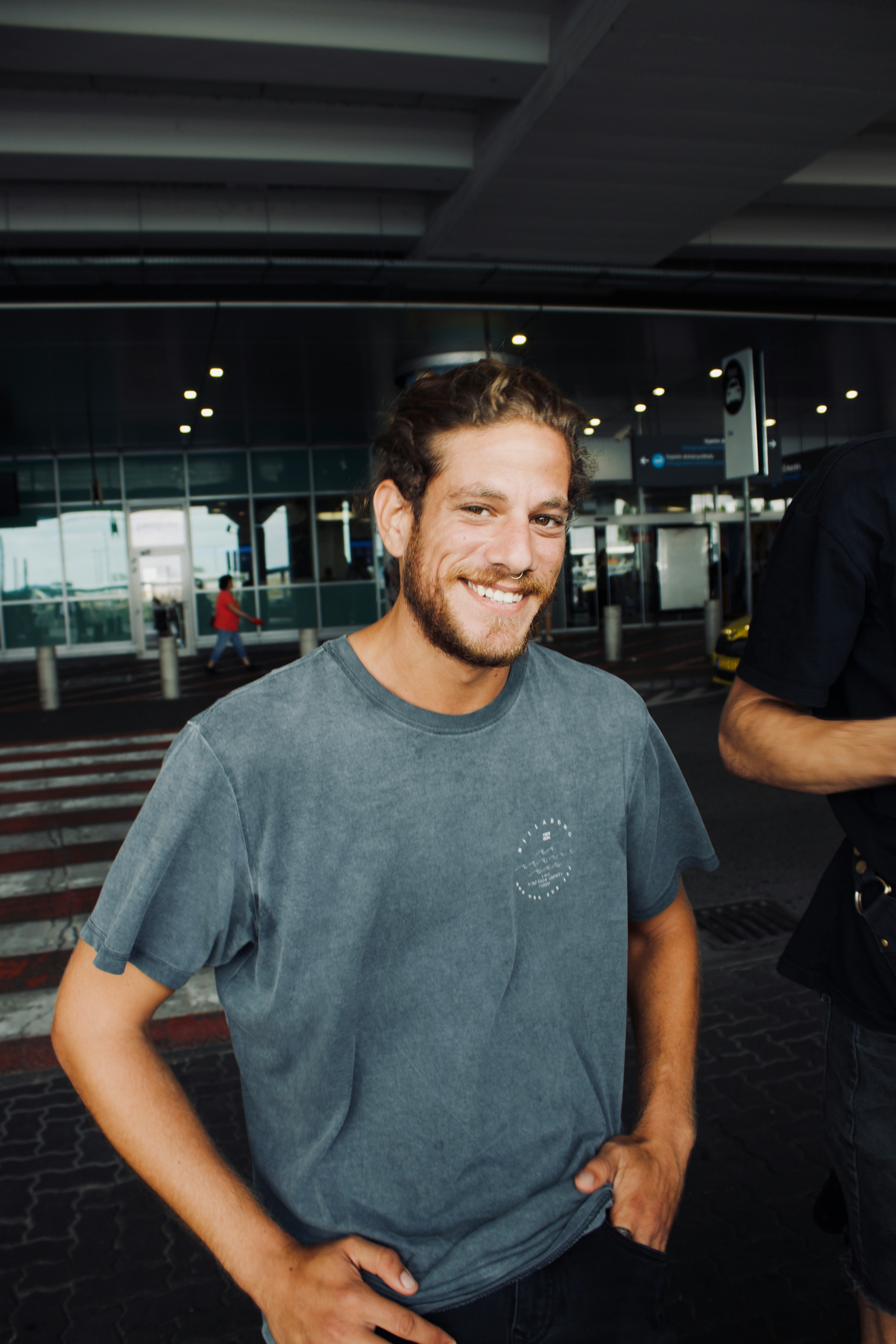 Un hombre sonriente en el exterior de un aeropuerto | Fuente: Unsplash