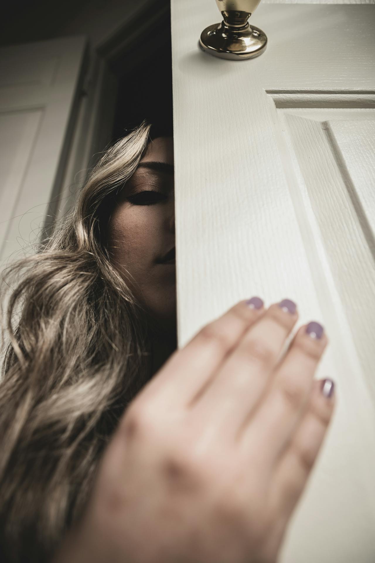 Una mujer sujetando una puerta de madera | Fuente: Pexels