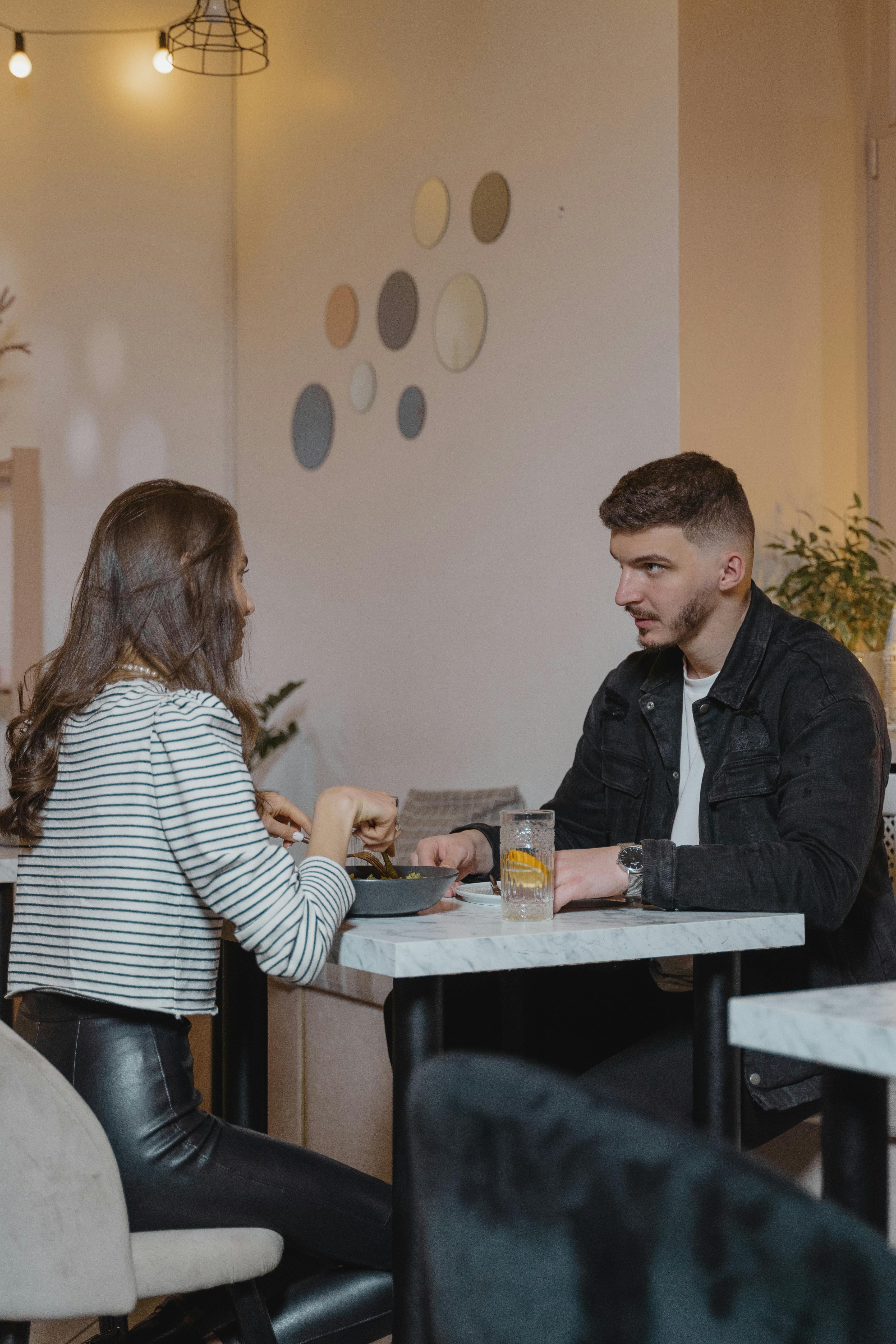 Un hombre y una mujer conversando mientras comen | Fuente: Pexels
