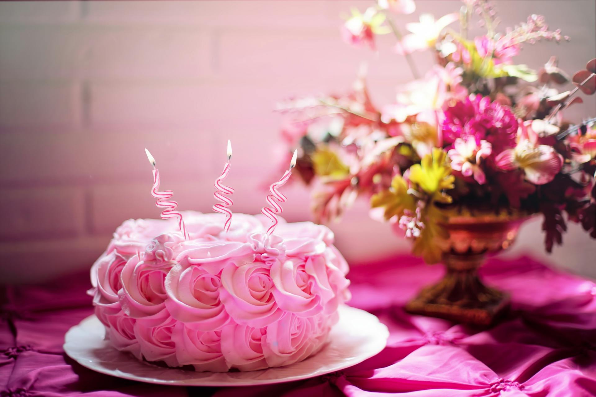 Pastel de flores rosas con velas | Fuente: Pexels
