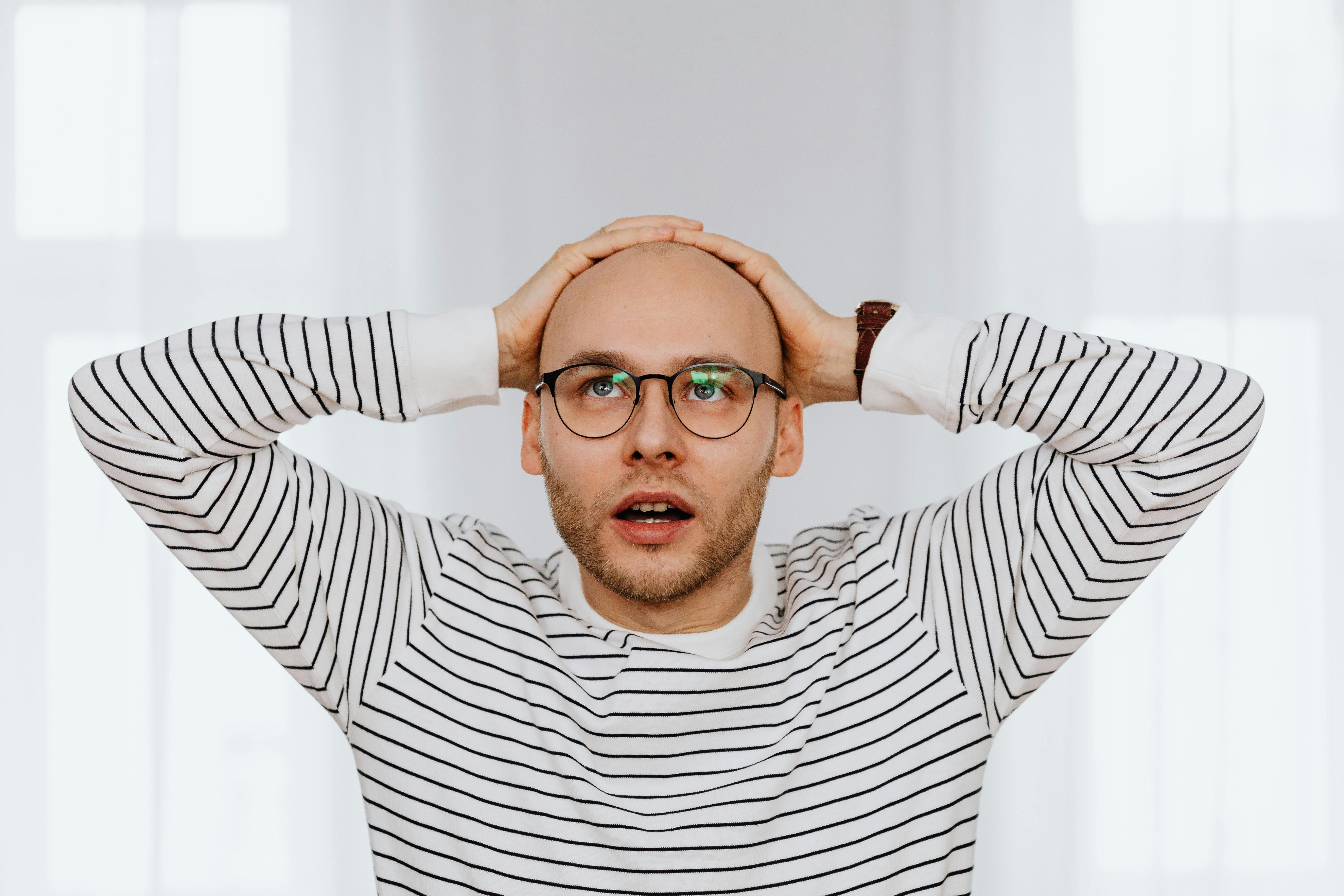 Un hombre sentado y sujetándose la cabeza | Fuente: Pexels