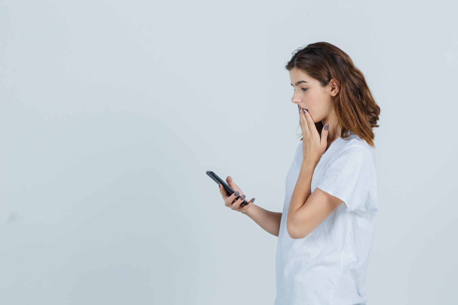 Una mujer preocupada mirando su teléfono | Fuente: Freepik