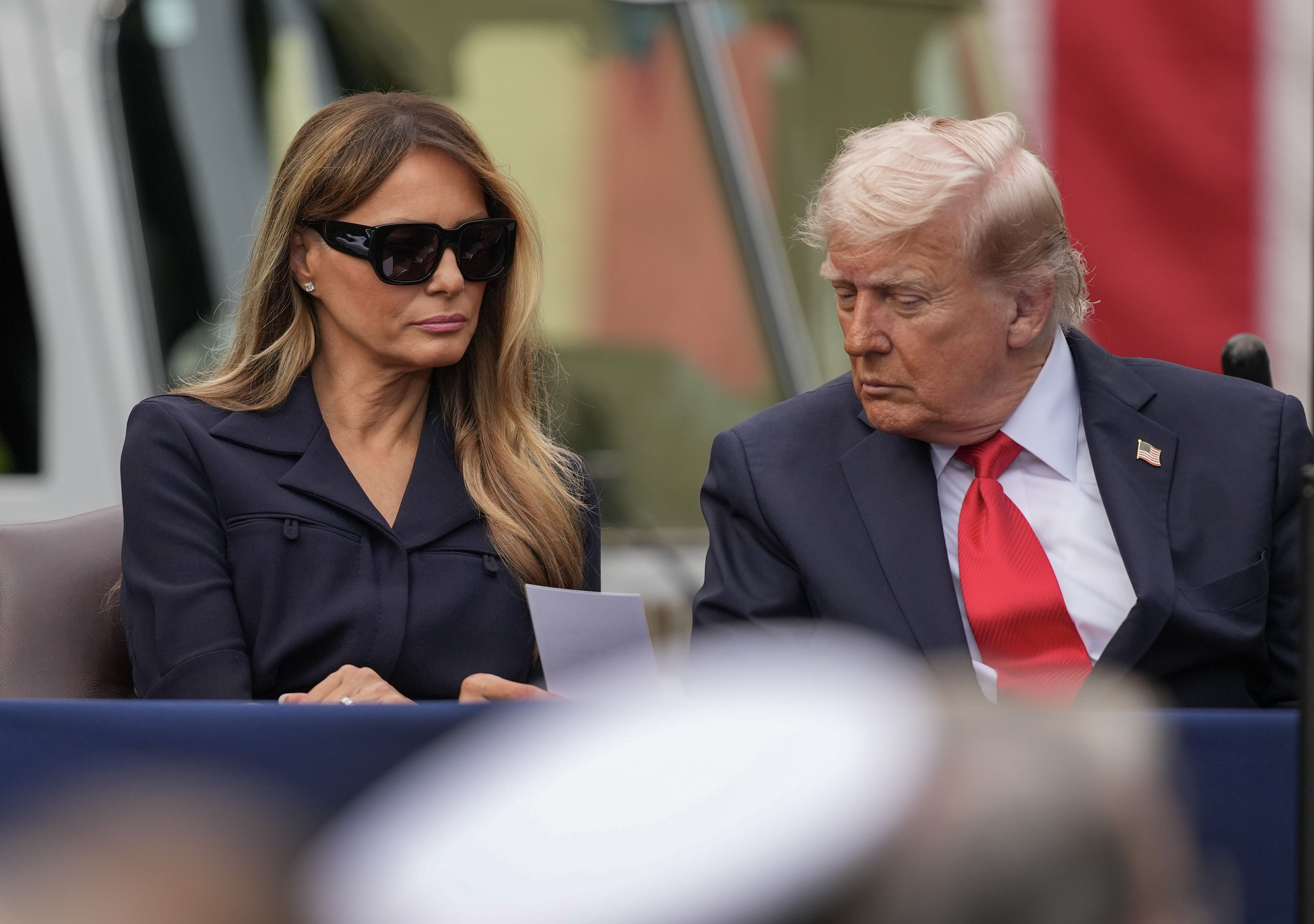 El presidente Donald Trump y la primera dama Melania Trump leen una nota que les han entregado mientras asisten a un acto conmemorativo en el patio del Pentágono el 11 de septiembre de 2025 en Arlington, Virginia | Fuente: Getty Images