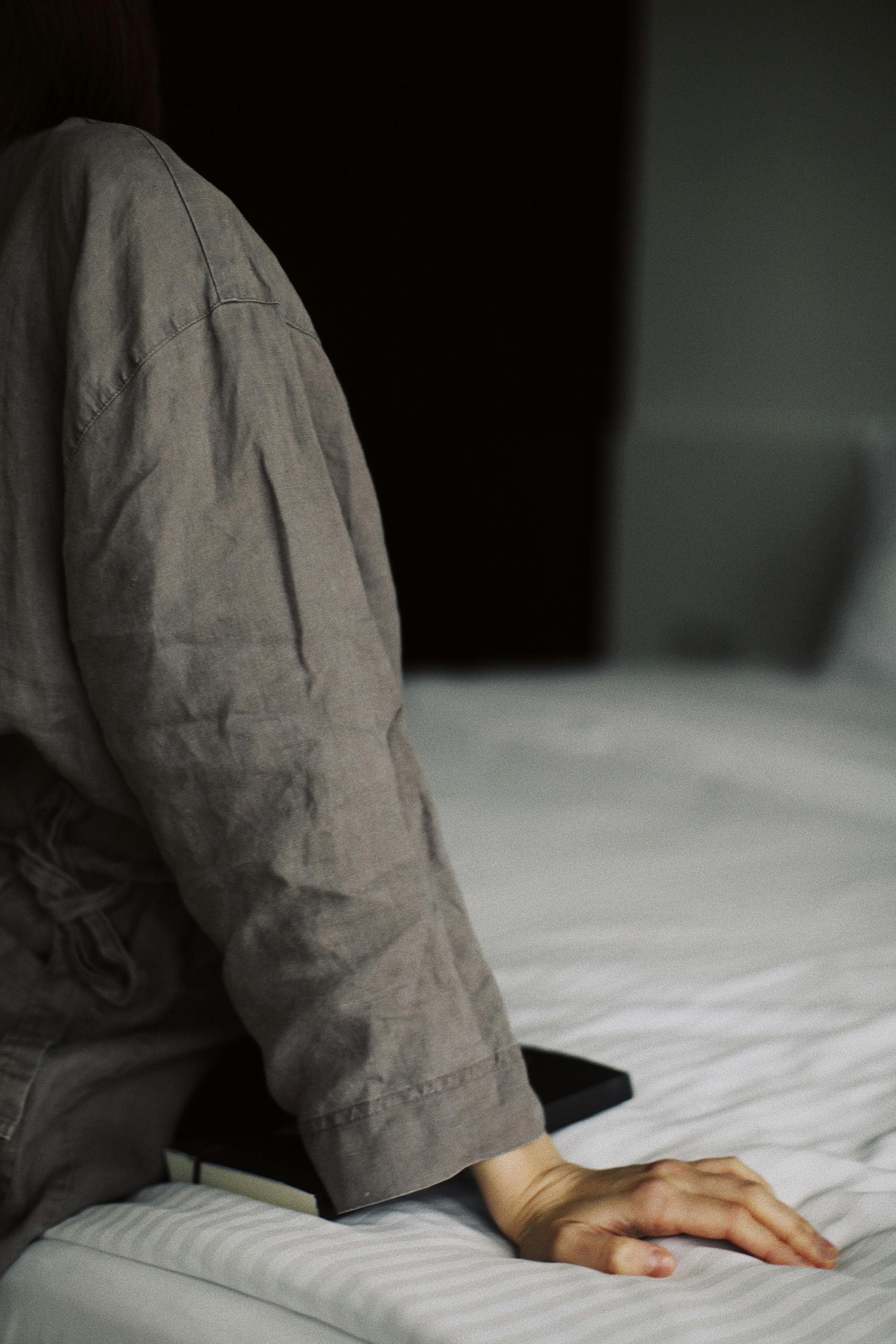 Primer plano de una mujer sentada en la cama | Fuente: Pexels