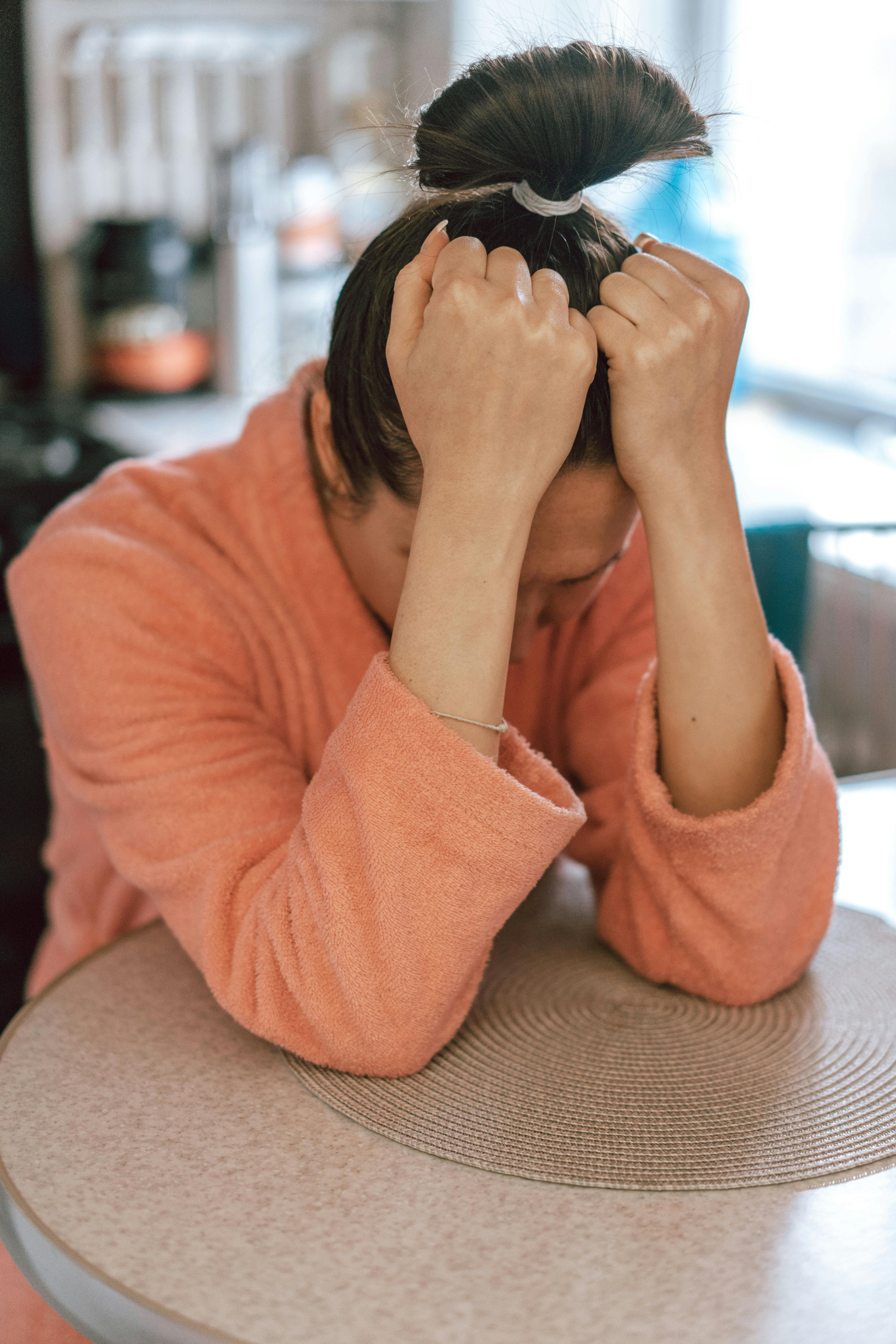 Una mujer triste en bata | Fuente: Pexels