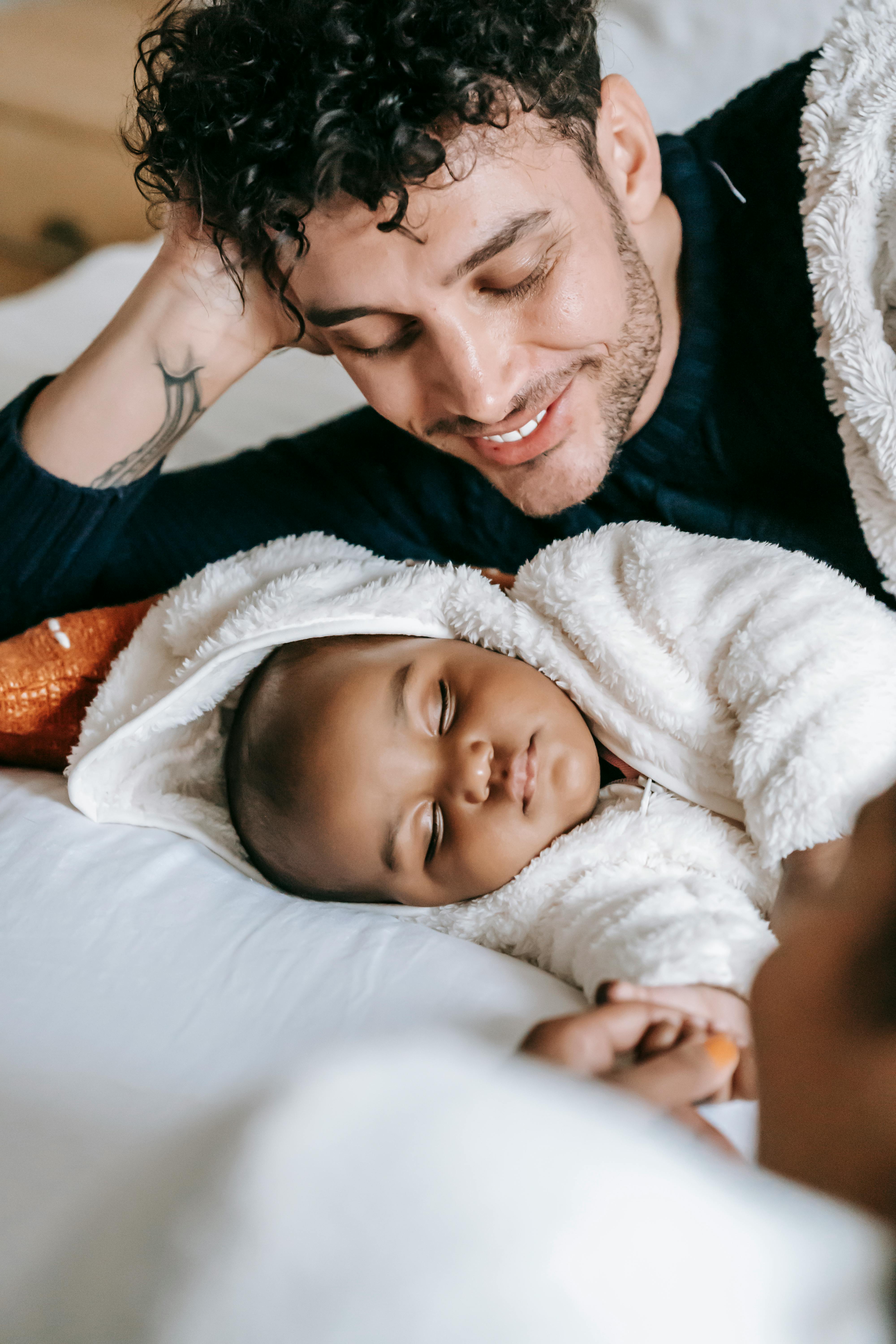 Padre viendo dormir a su bebé | Fuente: Pexels