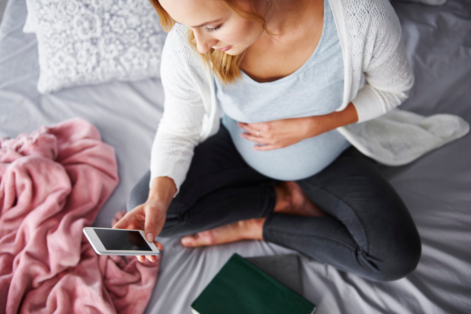 Una mujer embarazada mirando su teléfono | Fuente: Freepik