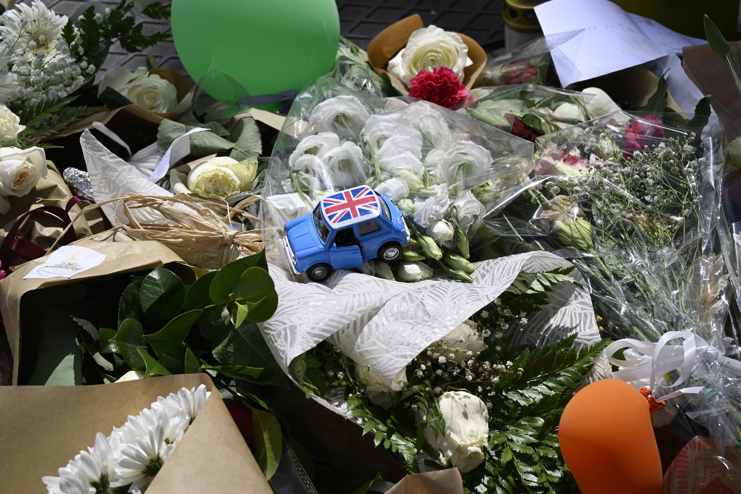 Un coche en miniatura con la bandera británica se ve sobre flores en un altar conmemorativo para recordar a las víctimas del accidente mortal del funicular de Gloria el 6 de septiembre de 2025 en Lisboa, Portugal. | Fuente: Getty Images