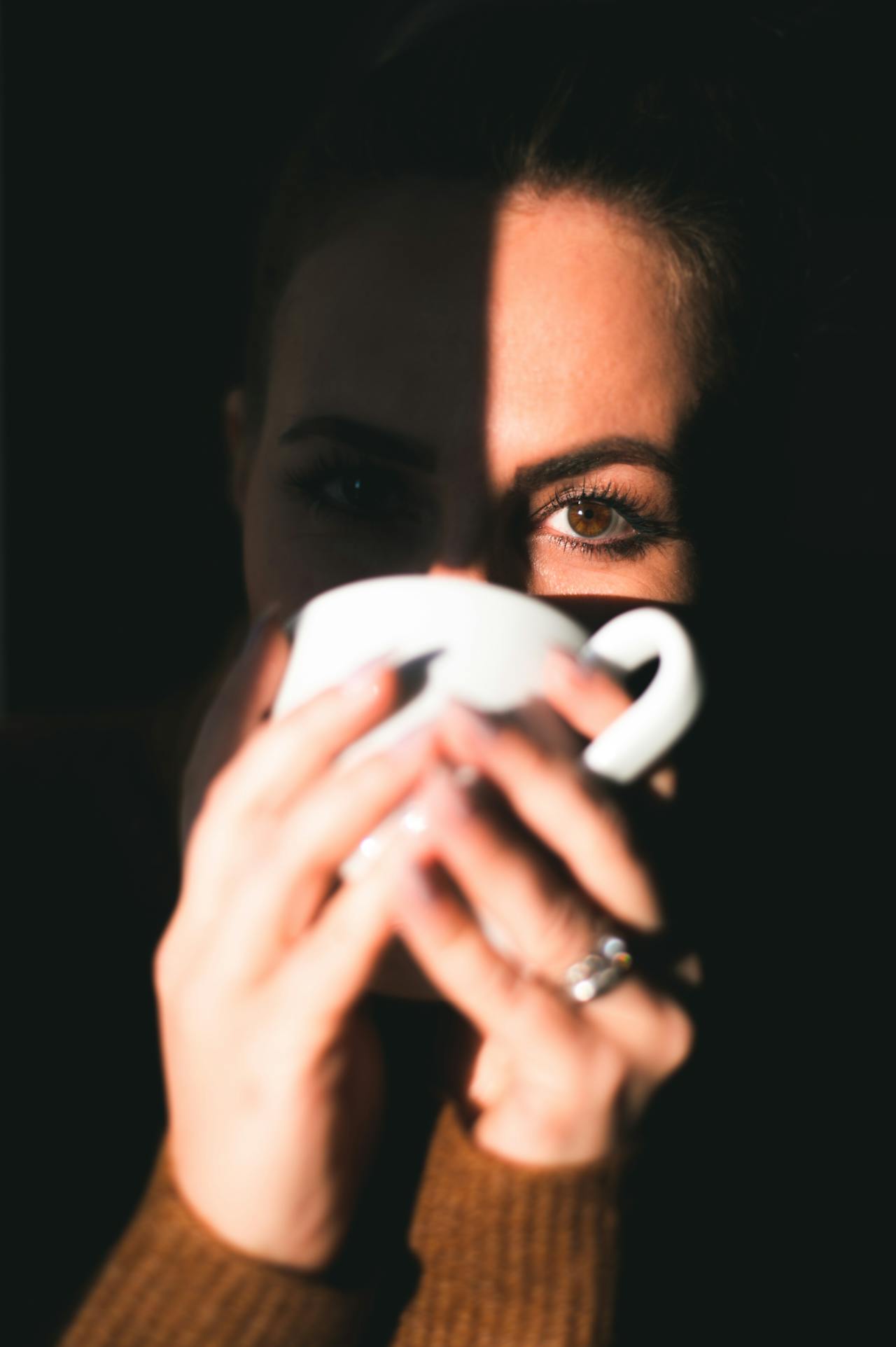 Una mujer bebiendo una bebida de una taza de cerámica | Fuente: Pexels