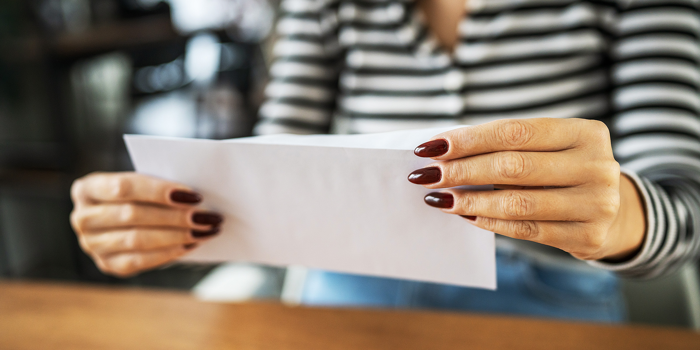 Una mujer sujetando una hoja de papel | Fuente: Shutterstock