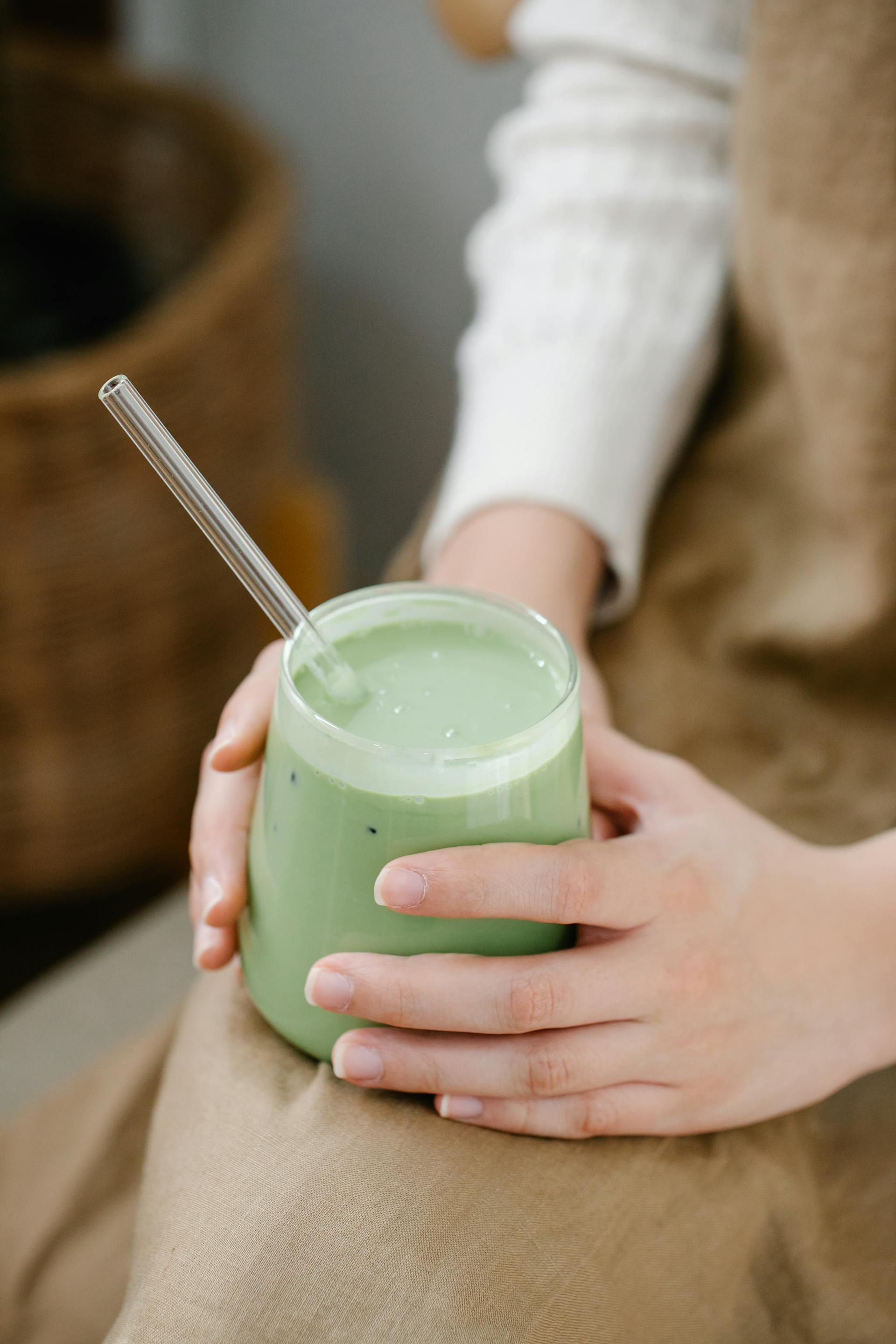 Una mujer con un batido verde en la mano | Fuente: Pexels