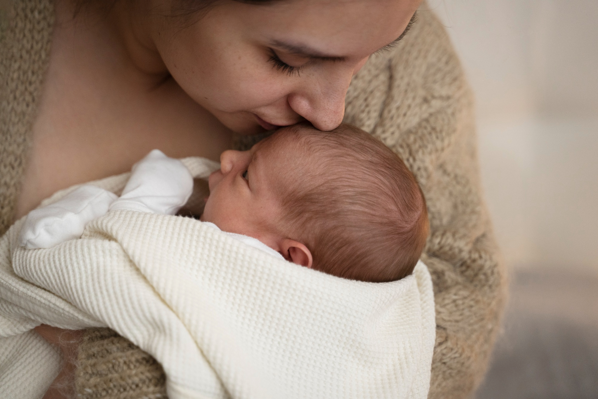 Una mujer besando a su bebé | Fuente: Freepik
