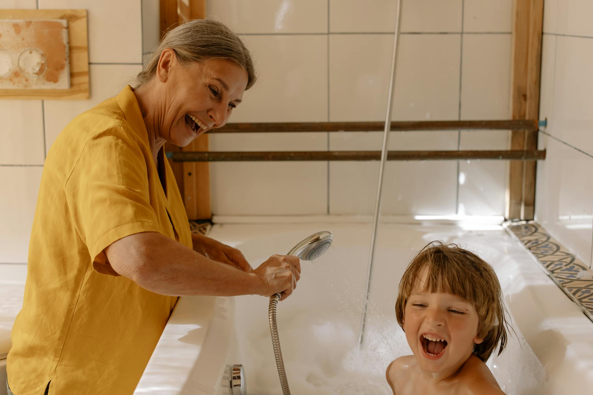 Abuela bañando a su nieto | Fuente: Pexels