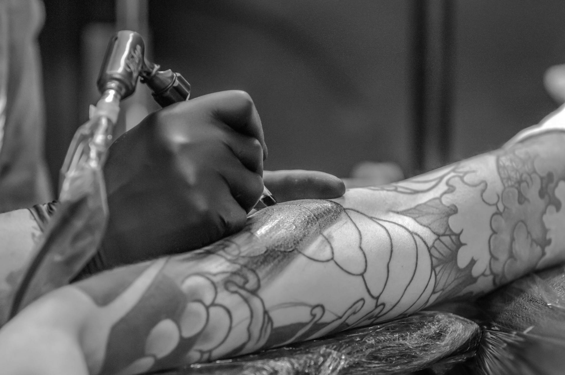 Un tatuador con un cliente | Fuente: Pexels