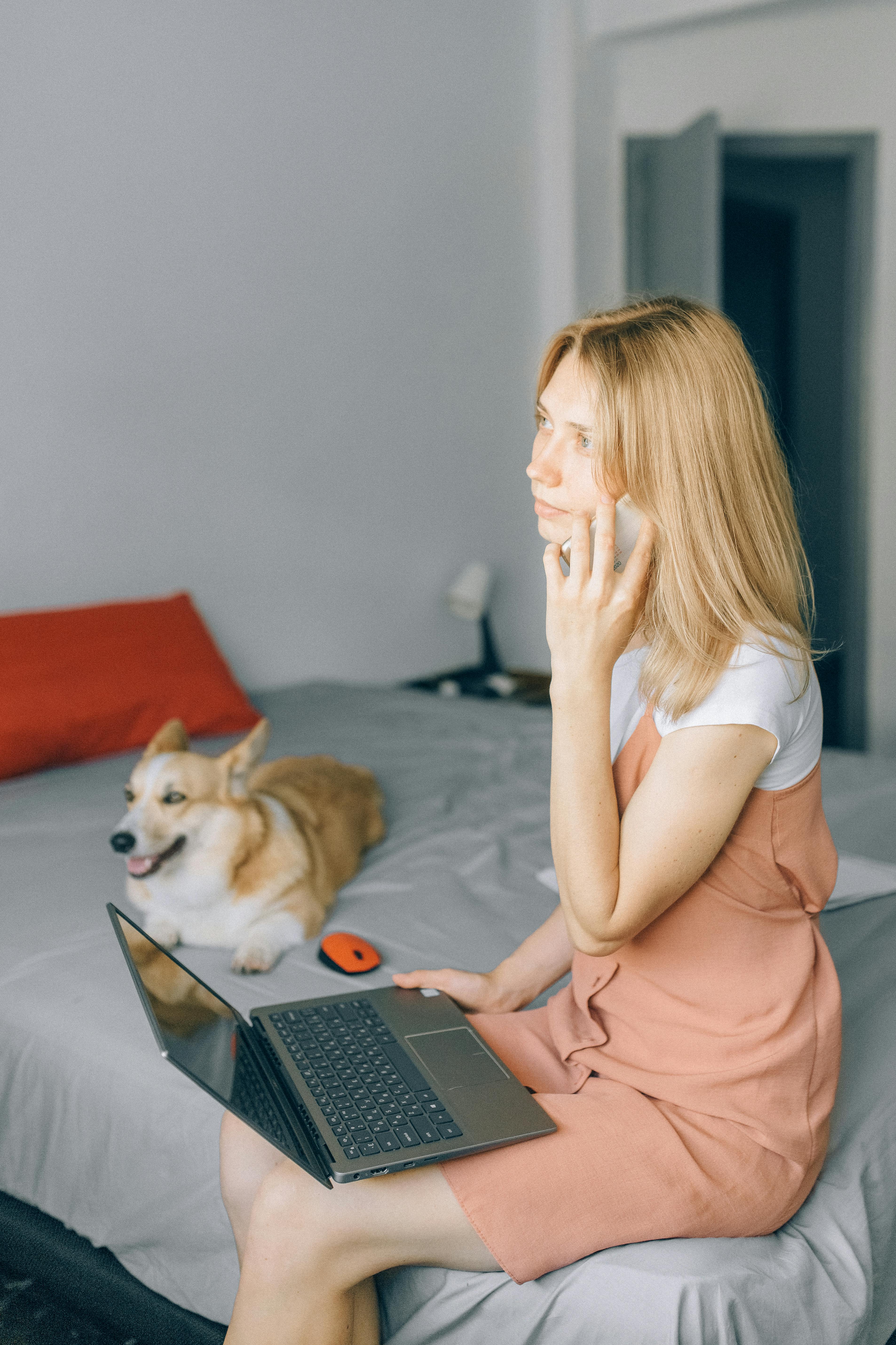 Mujer sentada en la cama mientras habla por teléfono | Fuente: Pexels