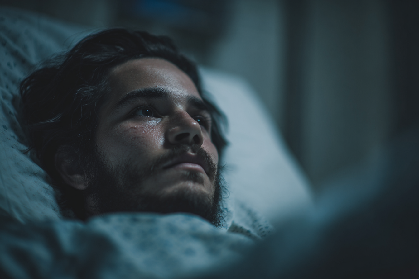 Un hombre en la cama de un hospital mirando a alguien | Fuente: Midjourney