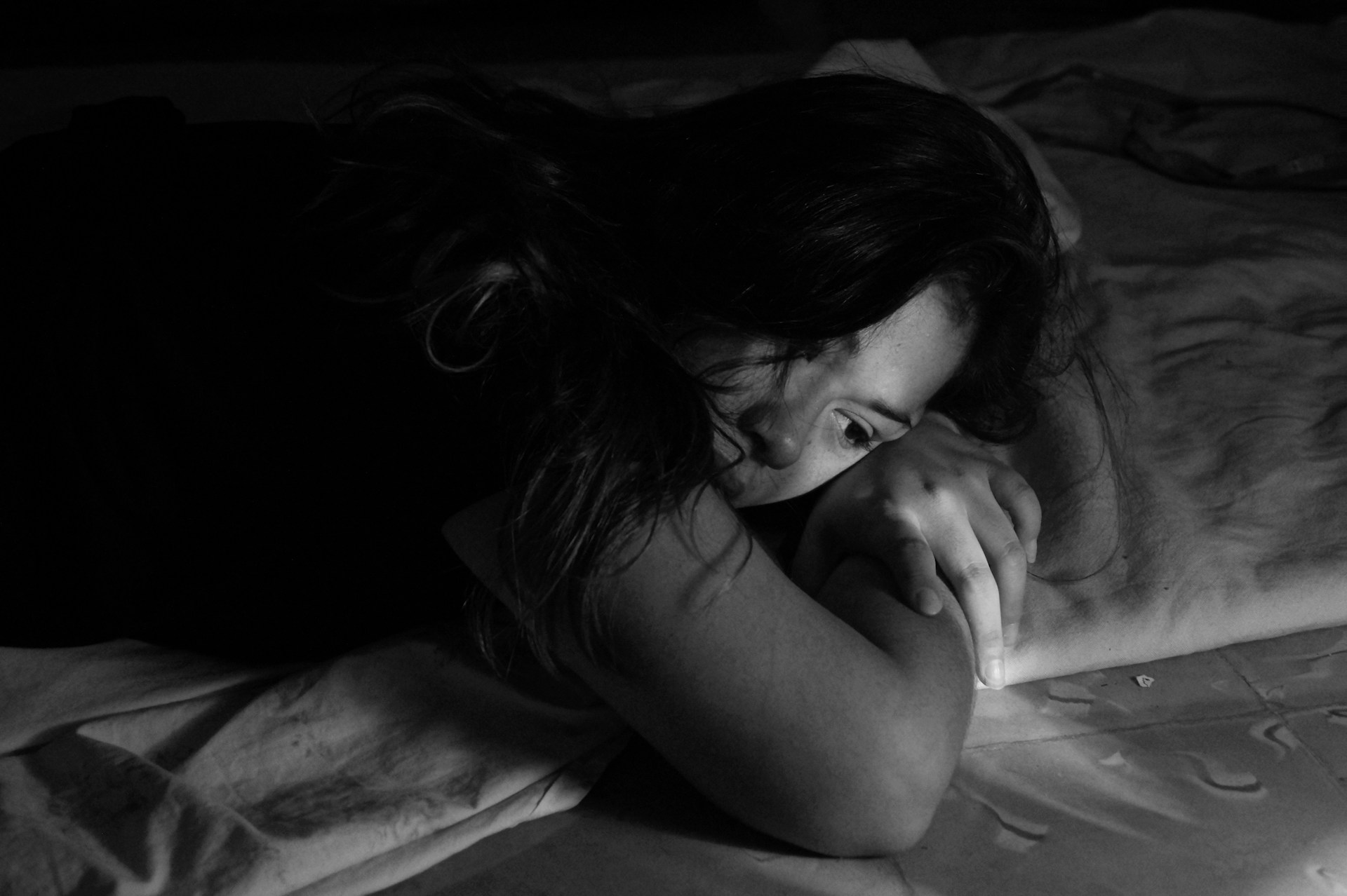 Una mujer triste tumbada en la cama | Fuente: Unsplash