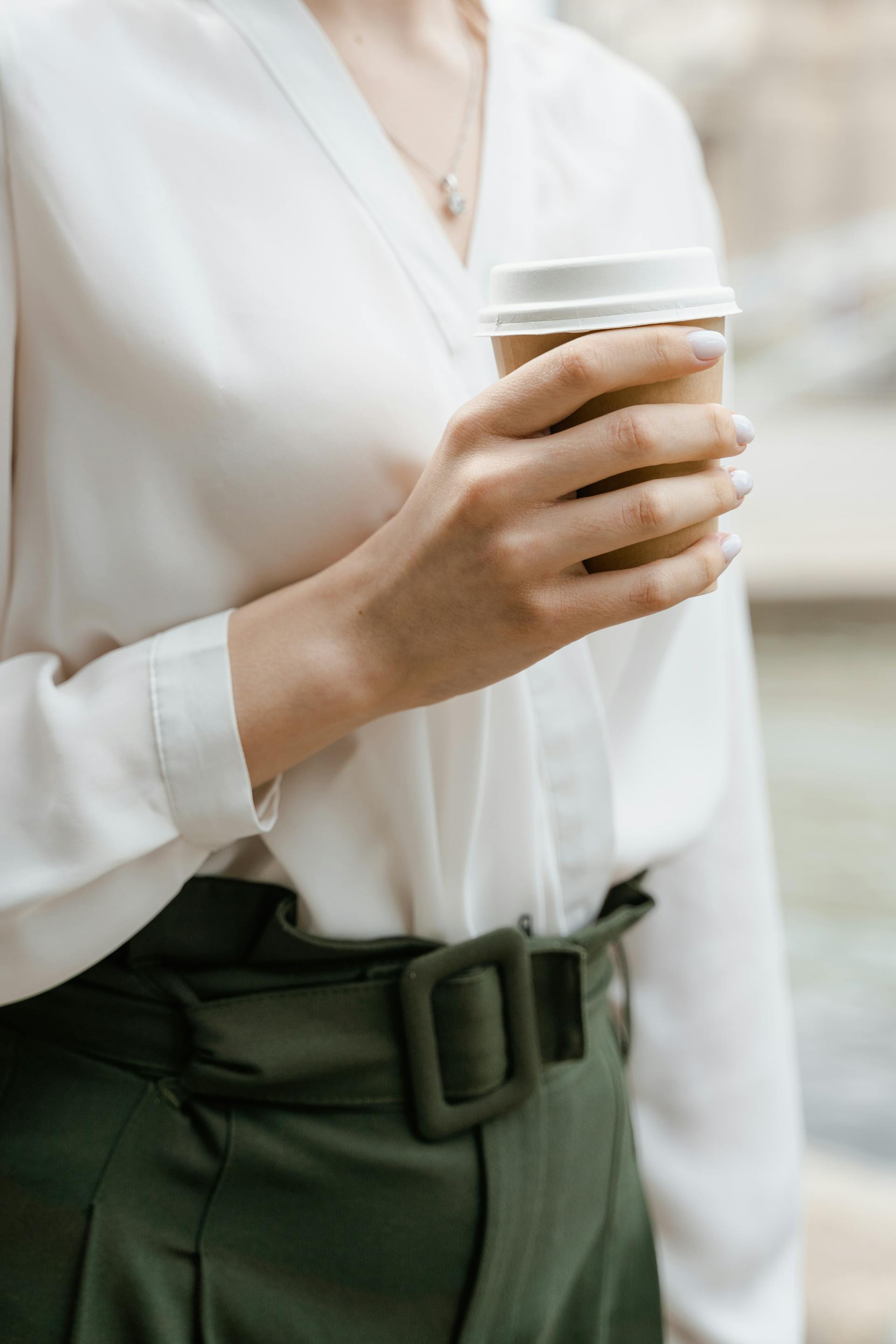 Primer plano de una mujer sosteniendo un café | Fuente: Pexels
