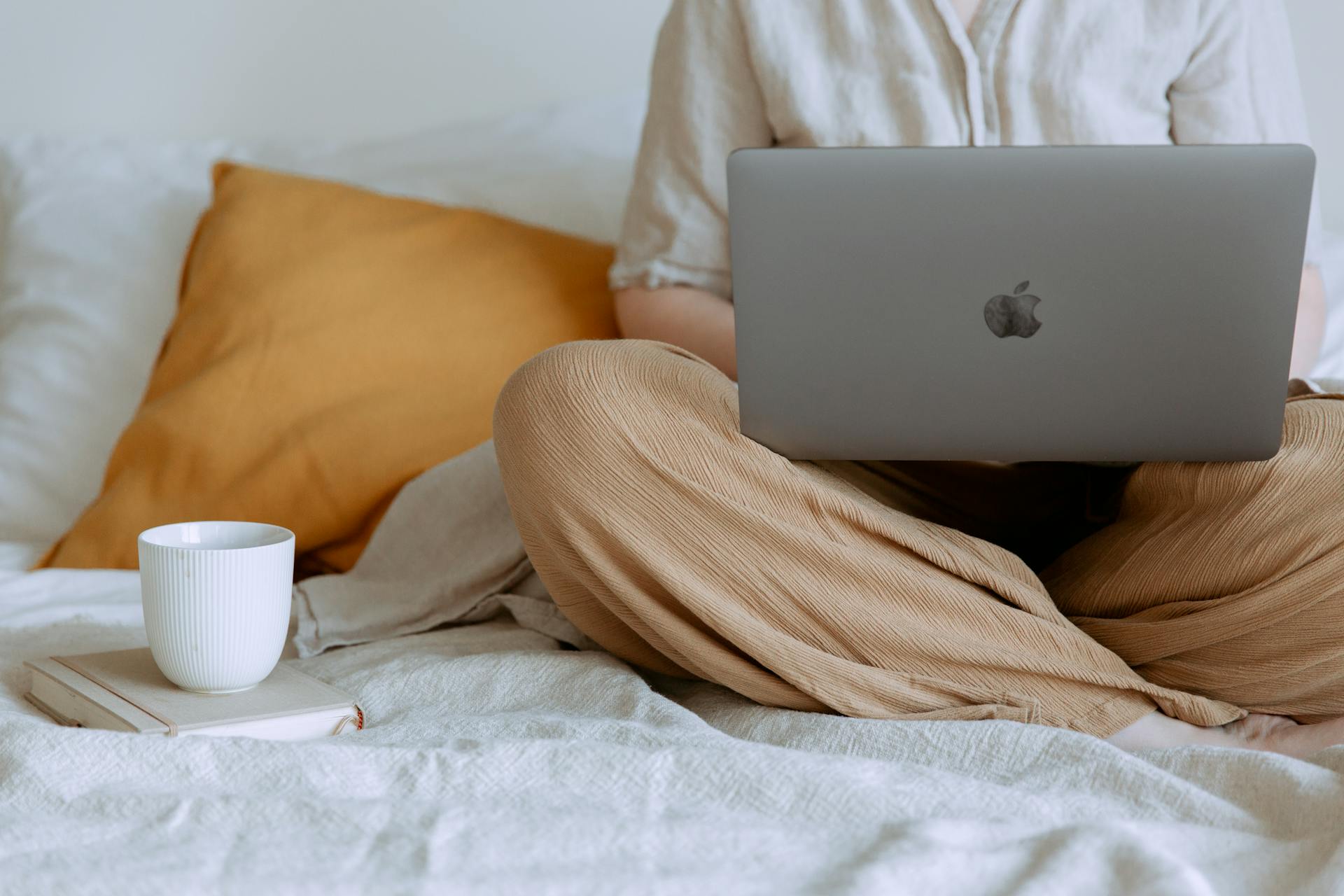 Mujer trabajando en su portátil en la cama | Fuente: Pexels
