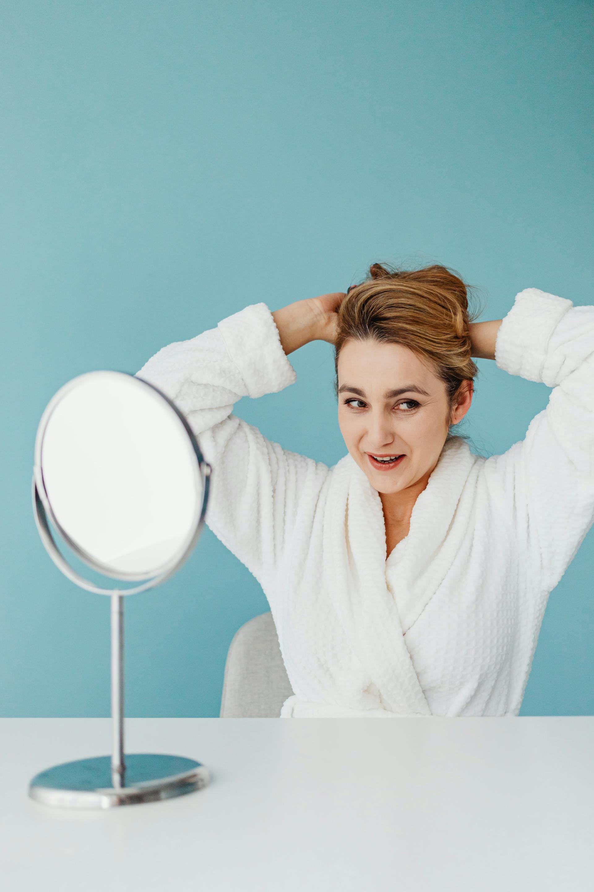 A smiling woman combing her hair | Source: Pexels
