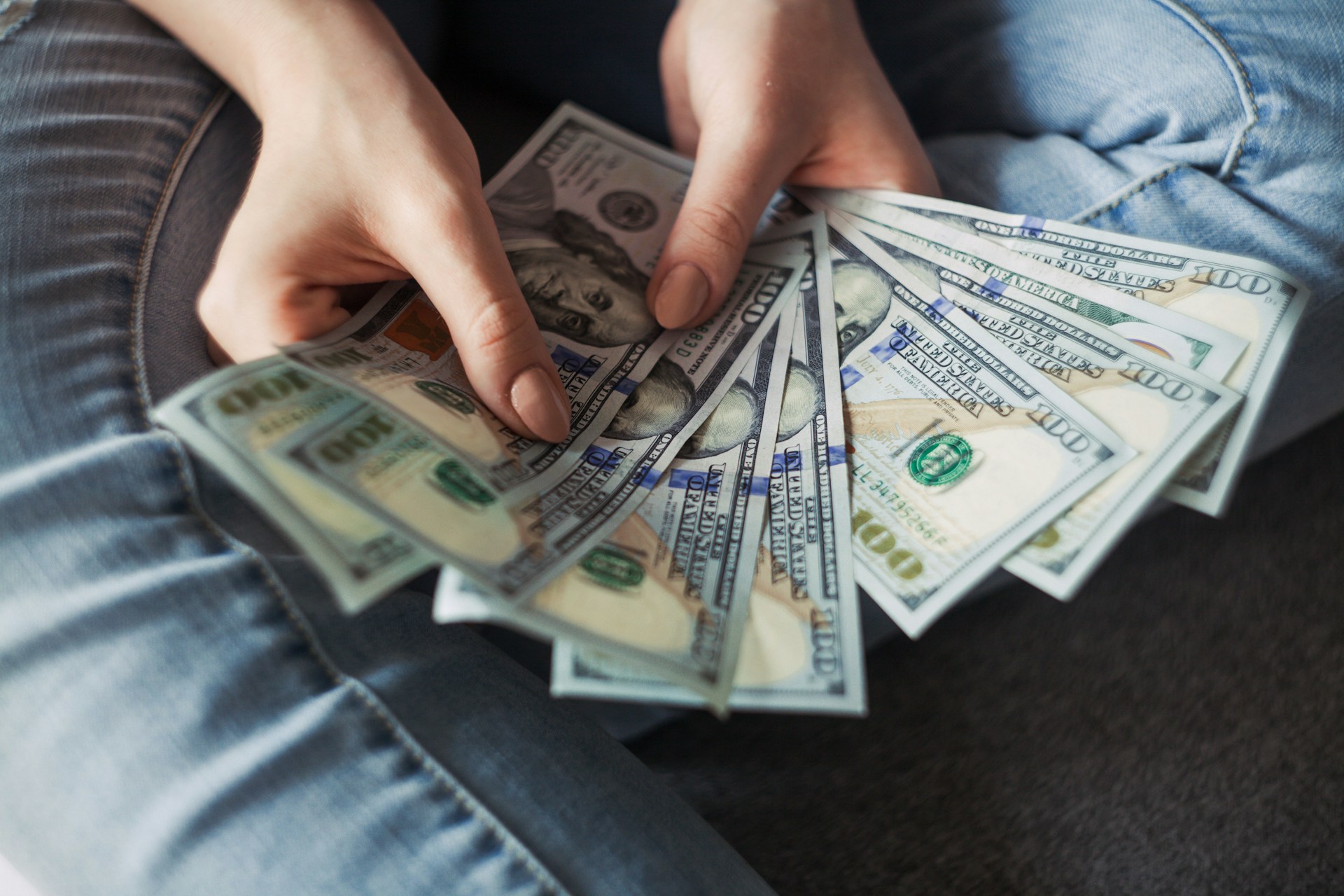 Una joven con billetes de un dólar en la mano | Fuente: Unsplash