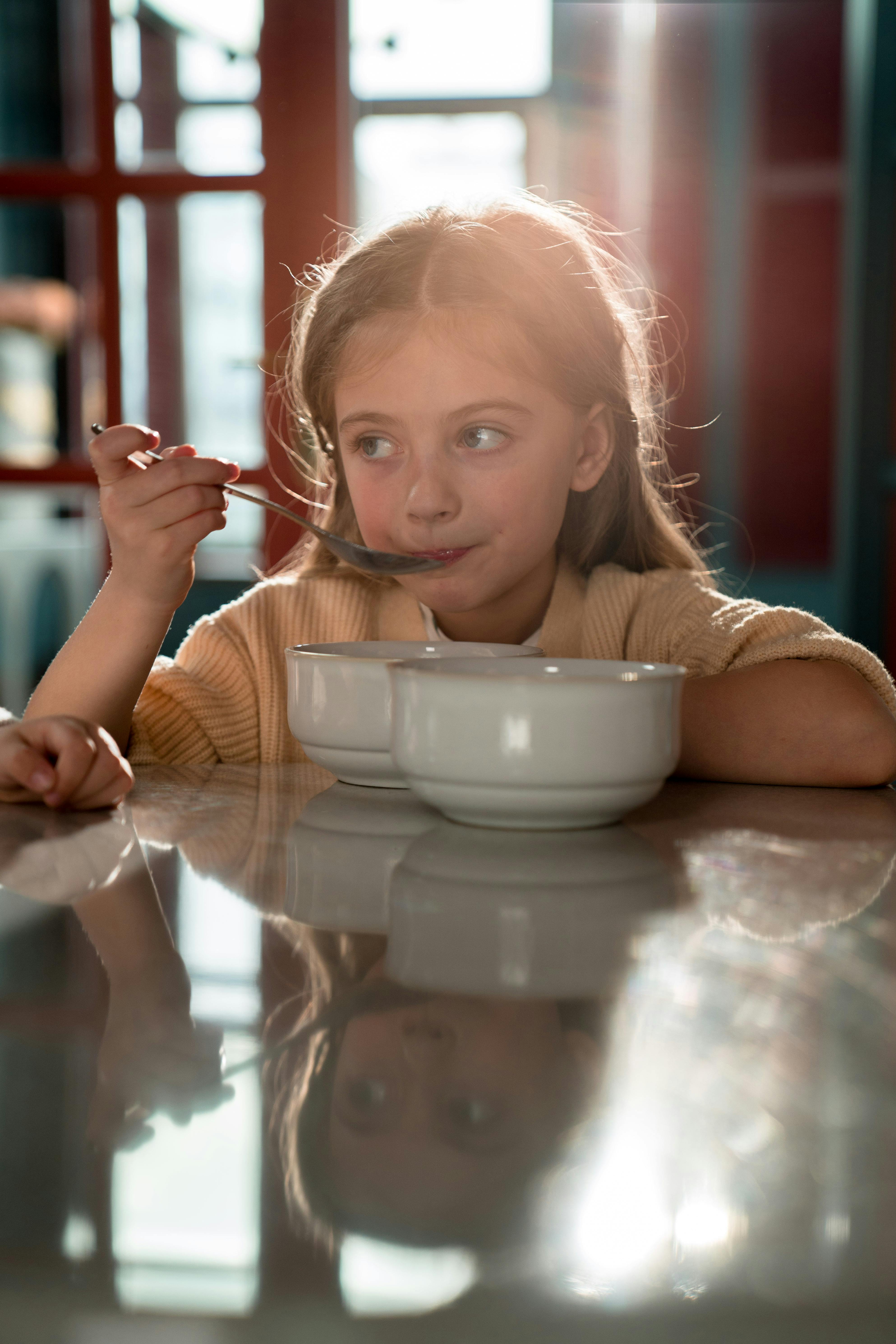 Niña sosteniendo una cuchara de plata | Fuente: Pexels