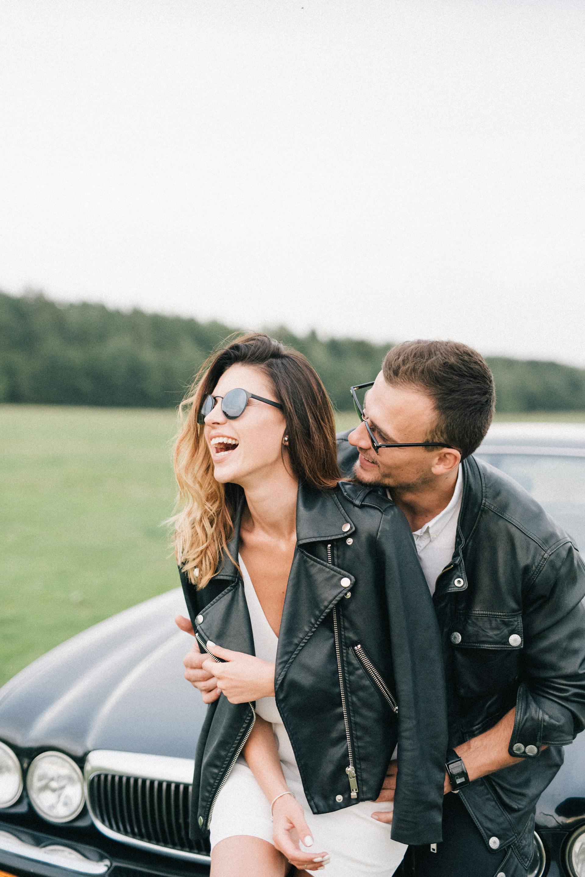 Una pareja feliz delante de un automóvil | Fuente: Pexels