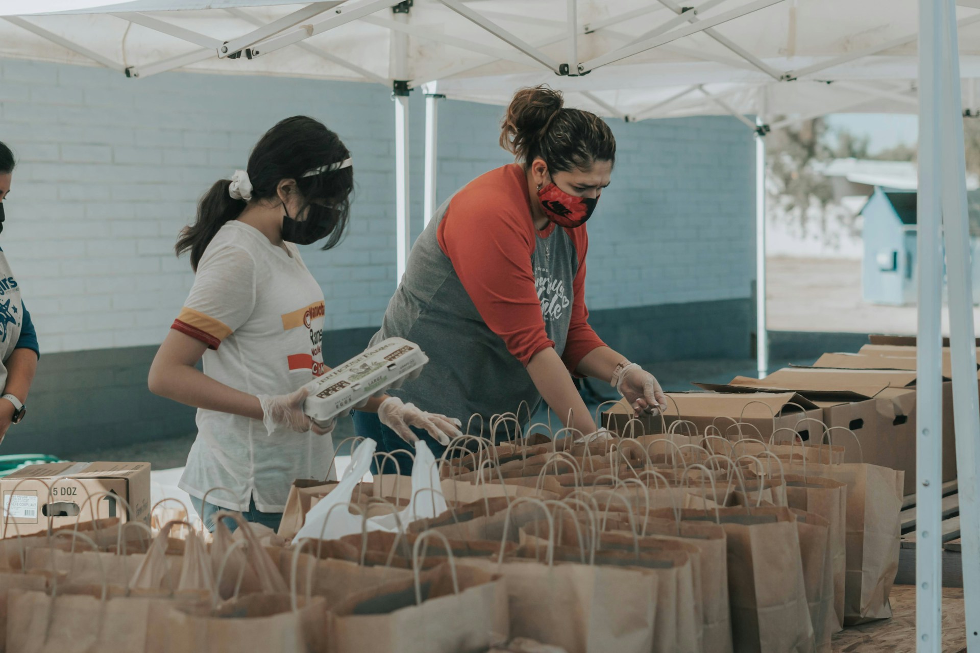 Voluntarios empacando artículos donados en bolsas | Fuente: Unsplash