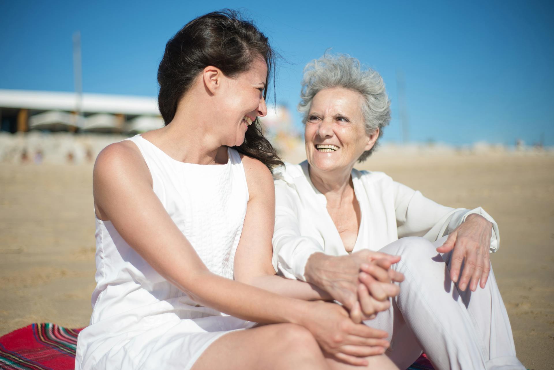 Madre e hija sentadas en la playa | Fuente: Pexels