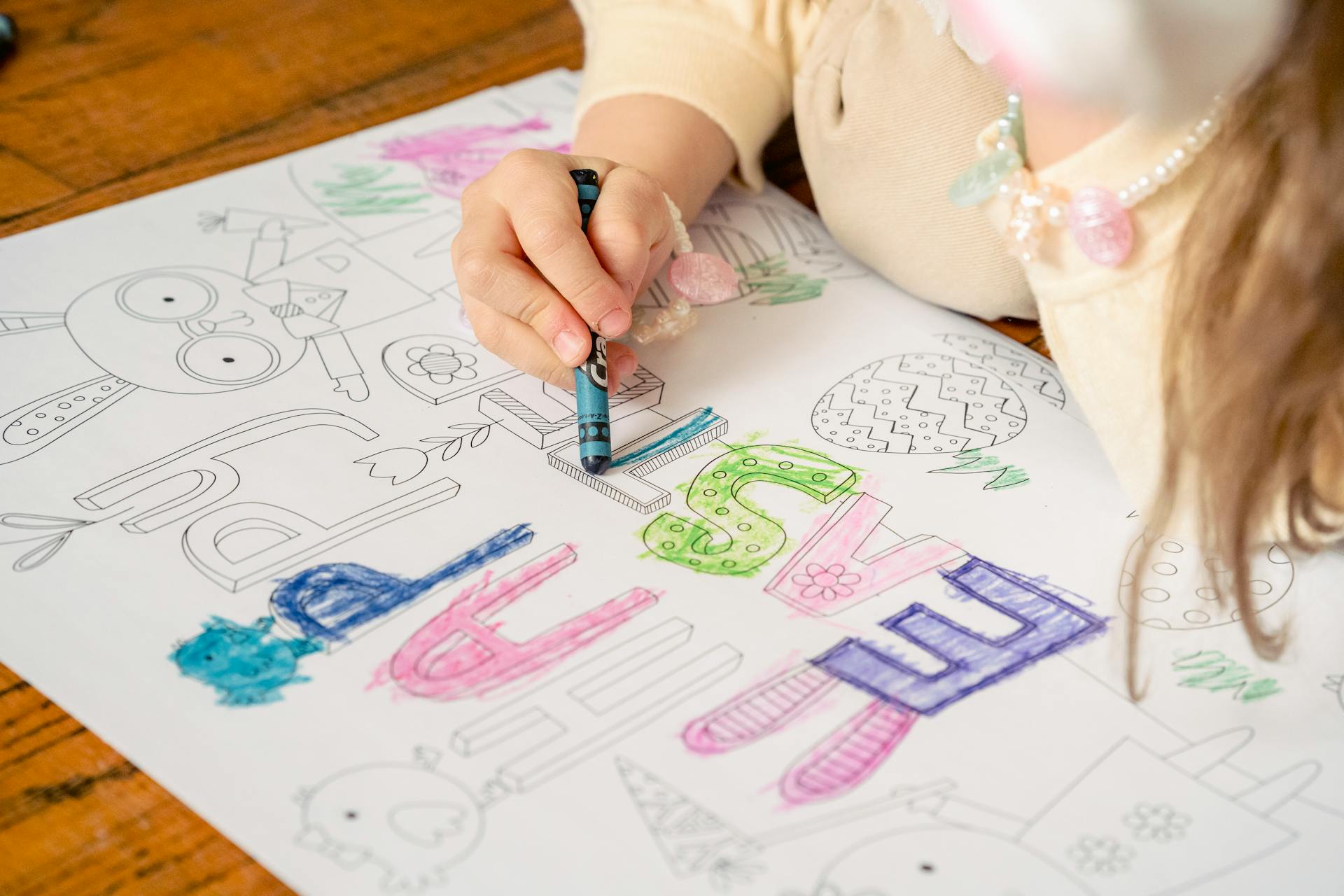 Primer plano de una niña coloreando en un papel | Fuente: Pexels