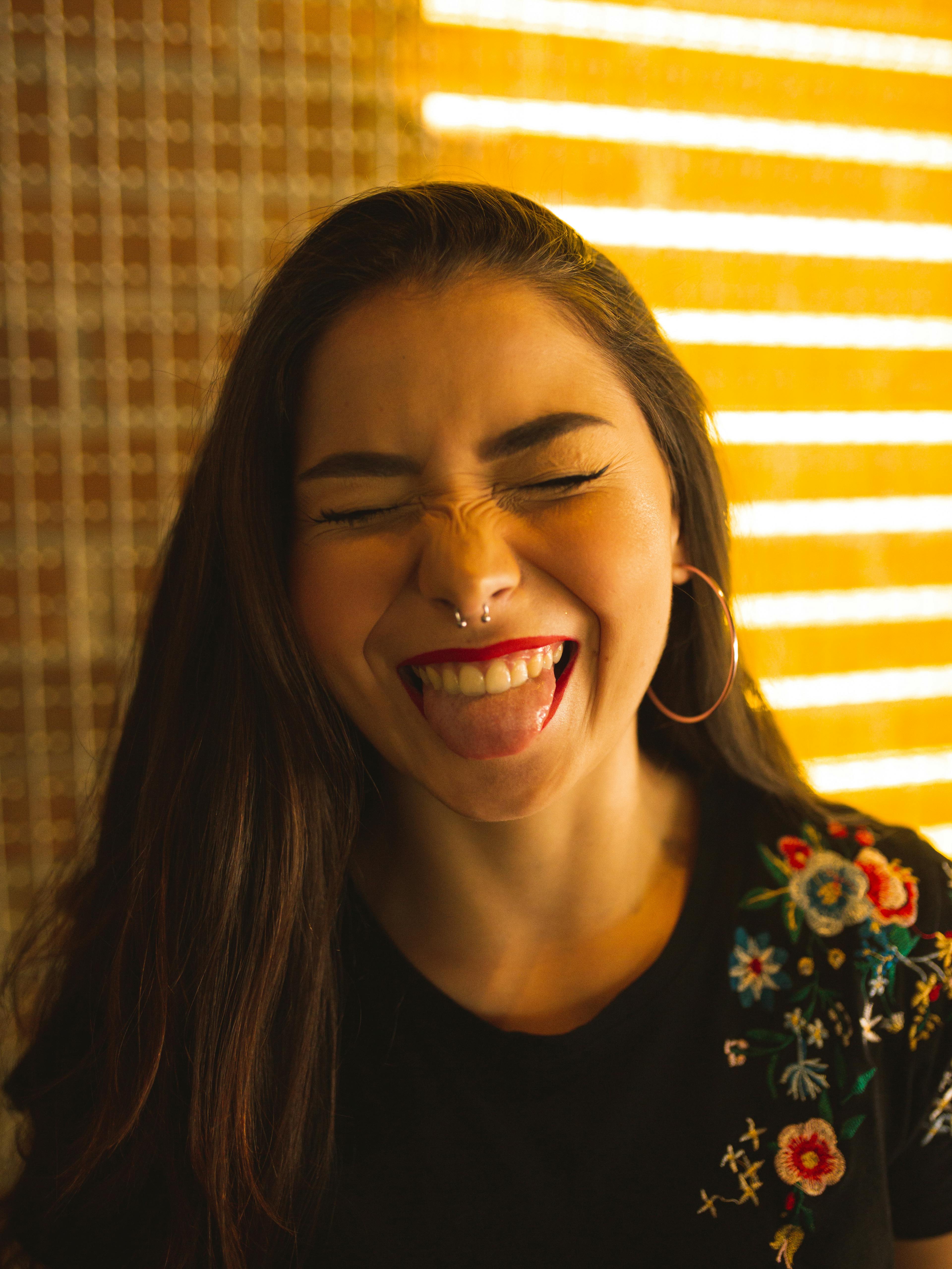 Una mujer riendo con la lengua fuera | Fuente: Pexels